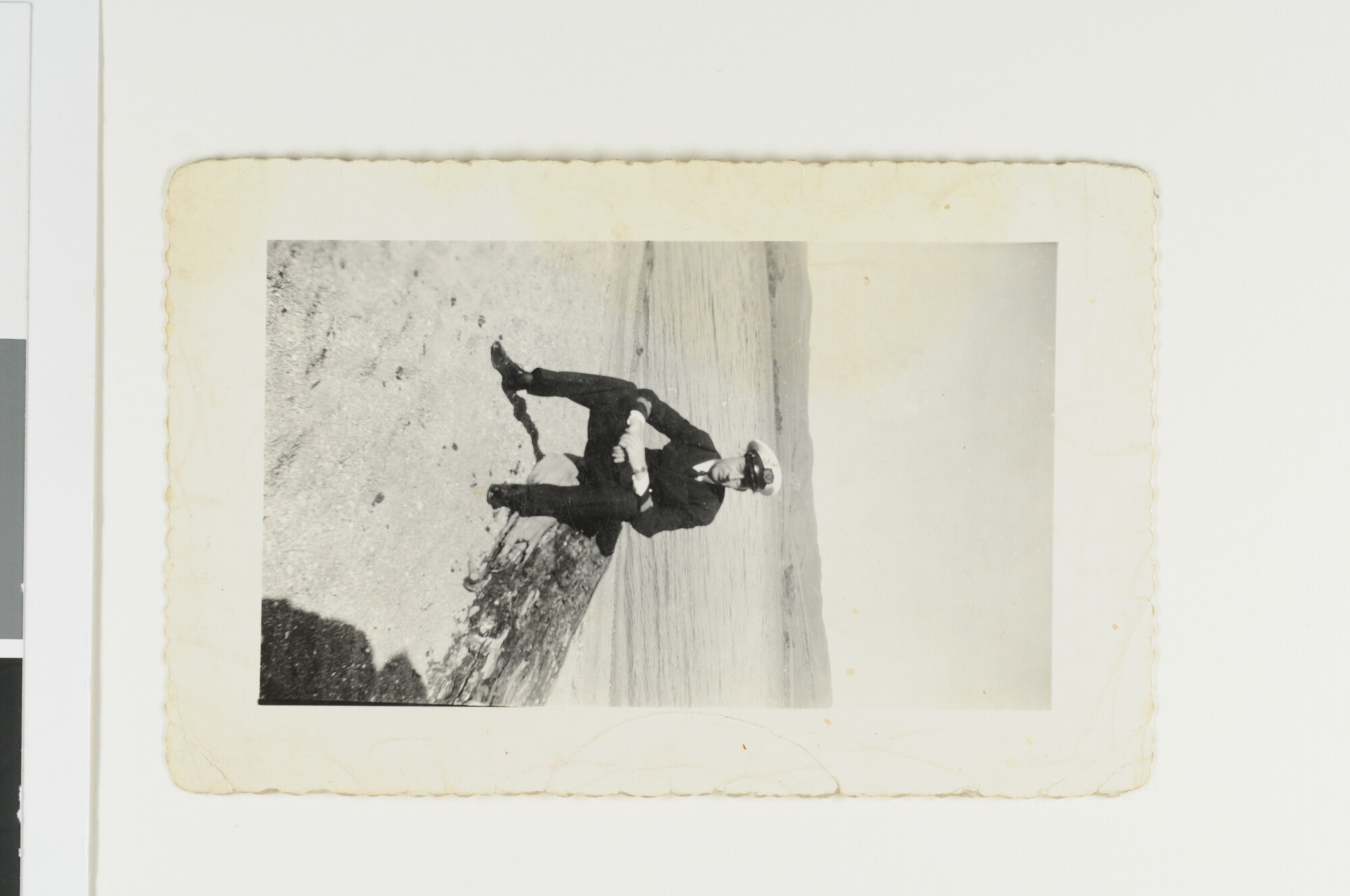 S.5548(108)22; Marconist J.D. van Schooten poseert, zittend op een stuk rots aan de kust; foto