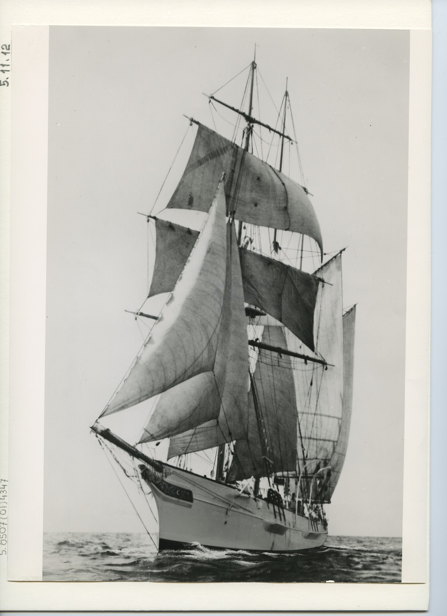 S.6507(01)4347; Een driemast topzeilschoener met witte romp zeilend op zee; foto
