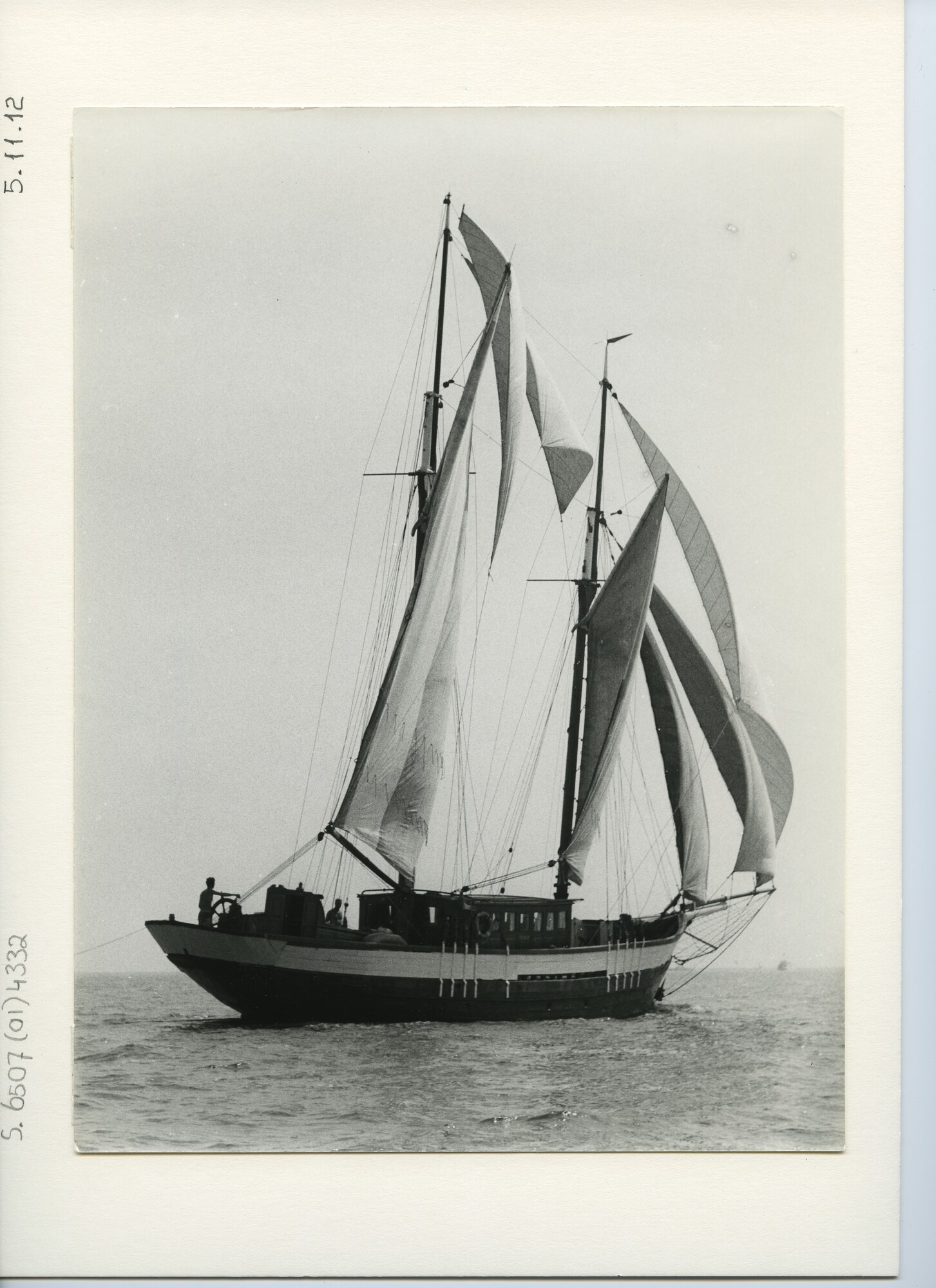 S.6507(01)4332; Een houten gaffelschoener met zwarte romp zeilend met ruime wind op zee; foto