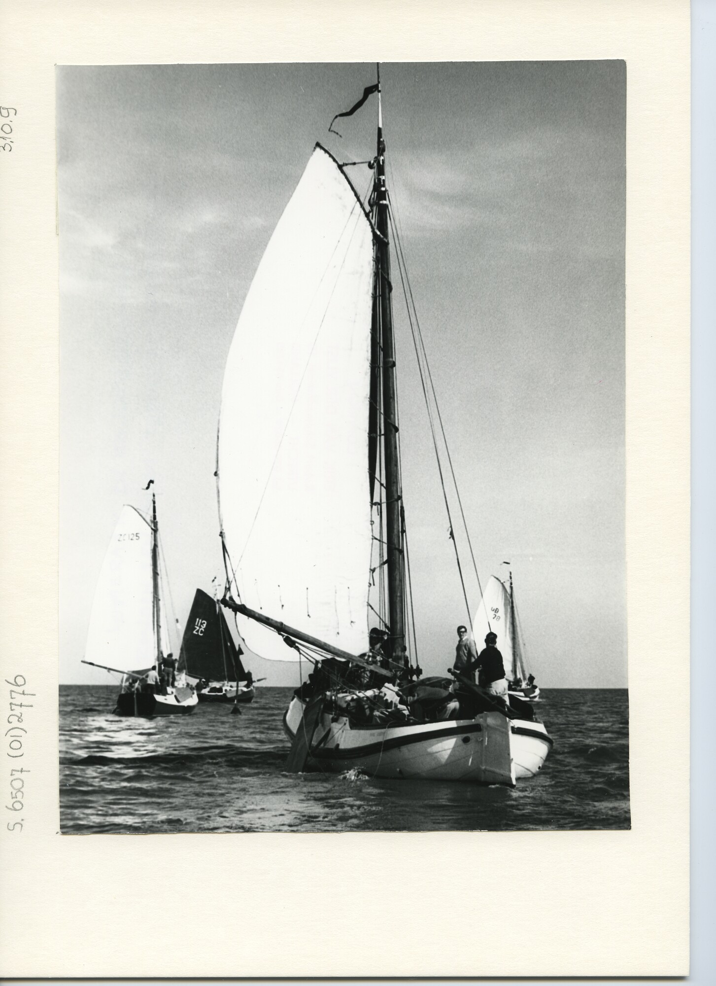 S.6507(01)2776; Achteraanzicht op een Lemsteraak en drie kajuitschouwen die een baken ronden op open water; foto