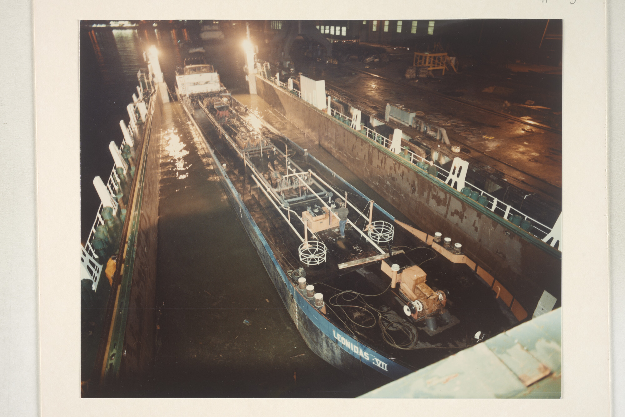 1996.3389; Avondopnames van het klaarmaken voor transport met een dokschip van de binnenvaarttankers ms. 'Leonidas VII' van Leonidas Tankvaart BV; fotoreportage