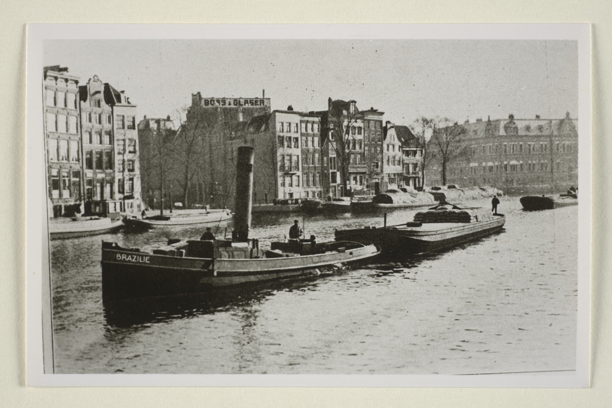 1995.5463; De stoomsleepboot 'Brazilië' van de Koninklijke Hollandsche Lloyd met een ponton op sleeptouw (vermoedelijk in een Amsterdamse gracht); foto