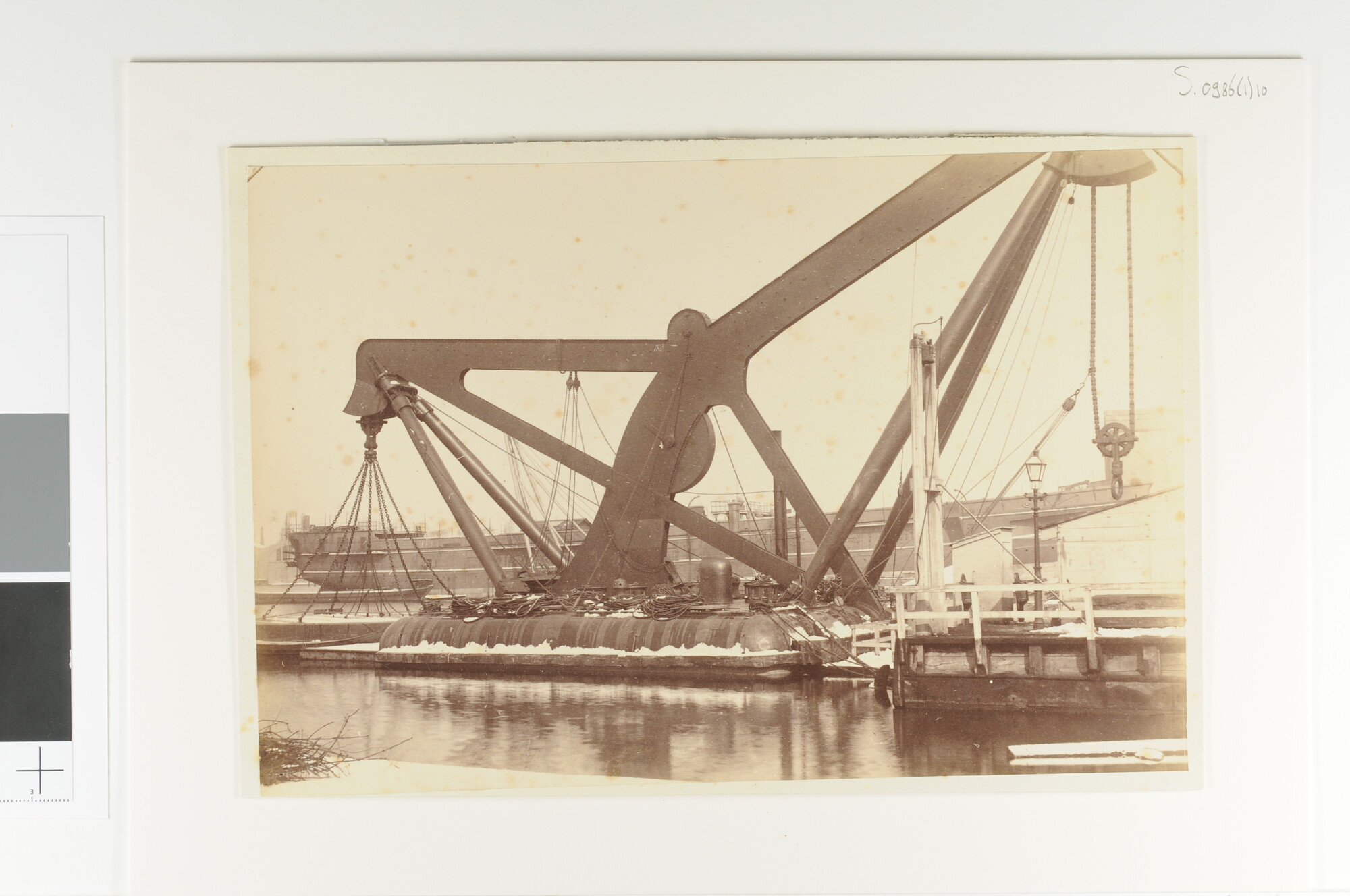 S.0986(01)10; Een drijvende stoomkraan in de winter afgemeerd aan de Rijkswerf te Amsterdam; foto