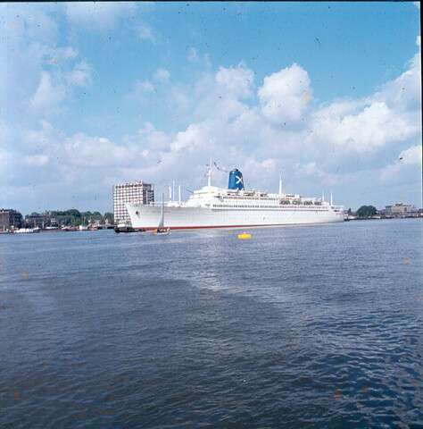S.9100(6993); Dia van het Griekse cruiseschip ss. Regina Magna (ex- Bremen van de HAPAG Lloyd) van de Carras Cruises bij de passage van het Havengebouw [...]; diapositief