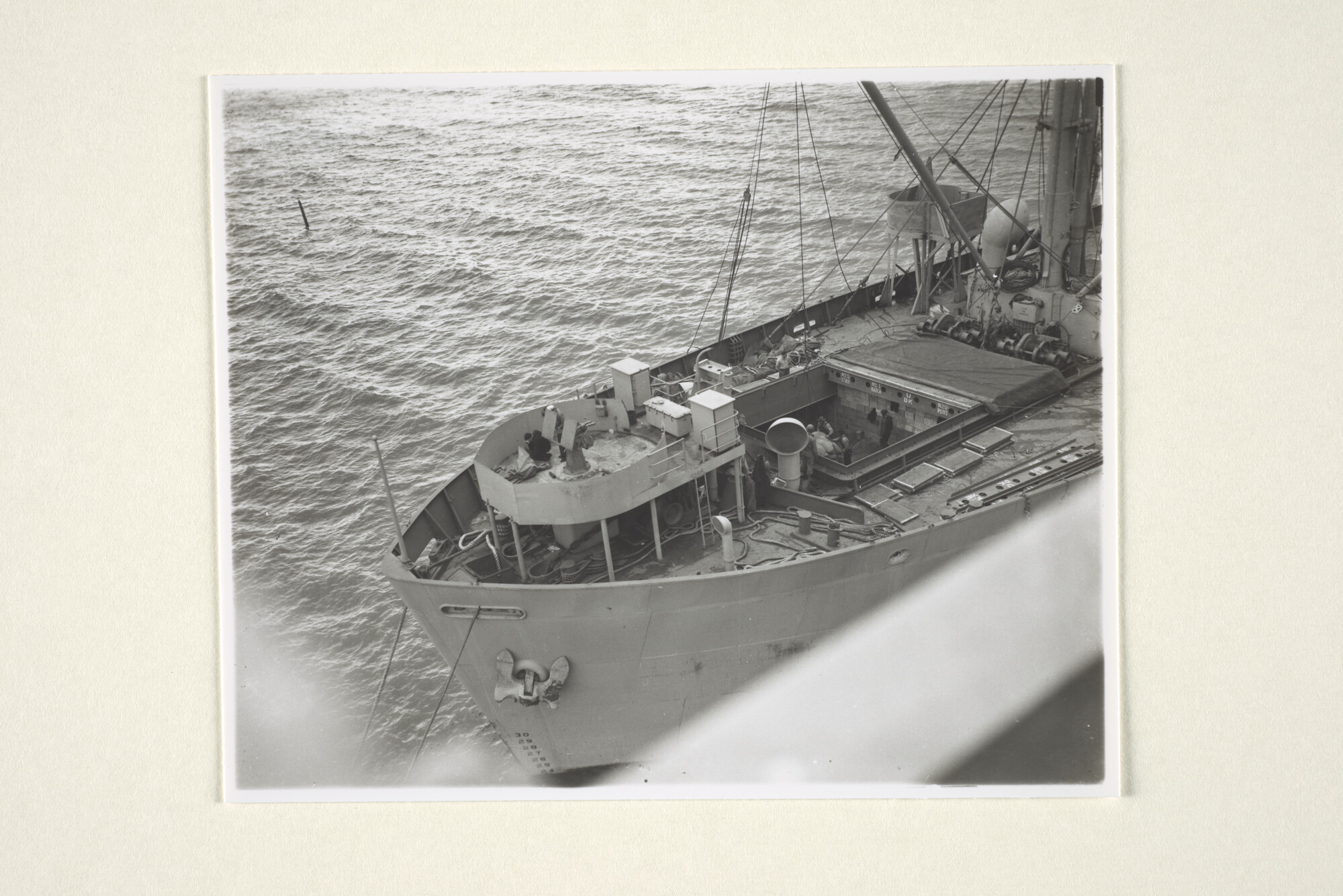 1997.4150; Detailfoto van het voorschip van een Amerikaans libertyschip, waarvan het voorste ruim wordt geladen met dozen en zakken; foto