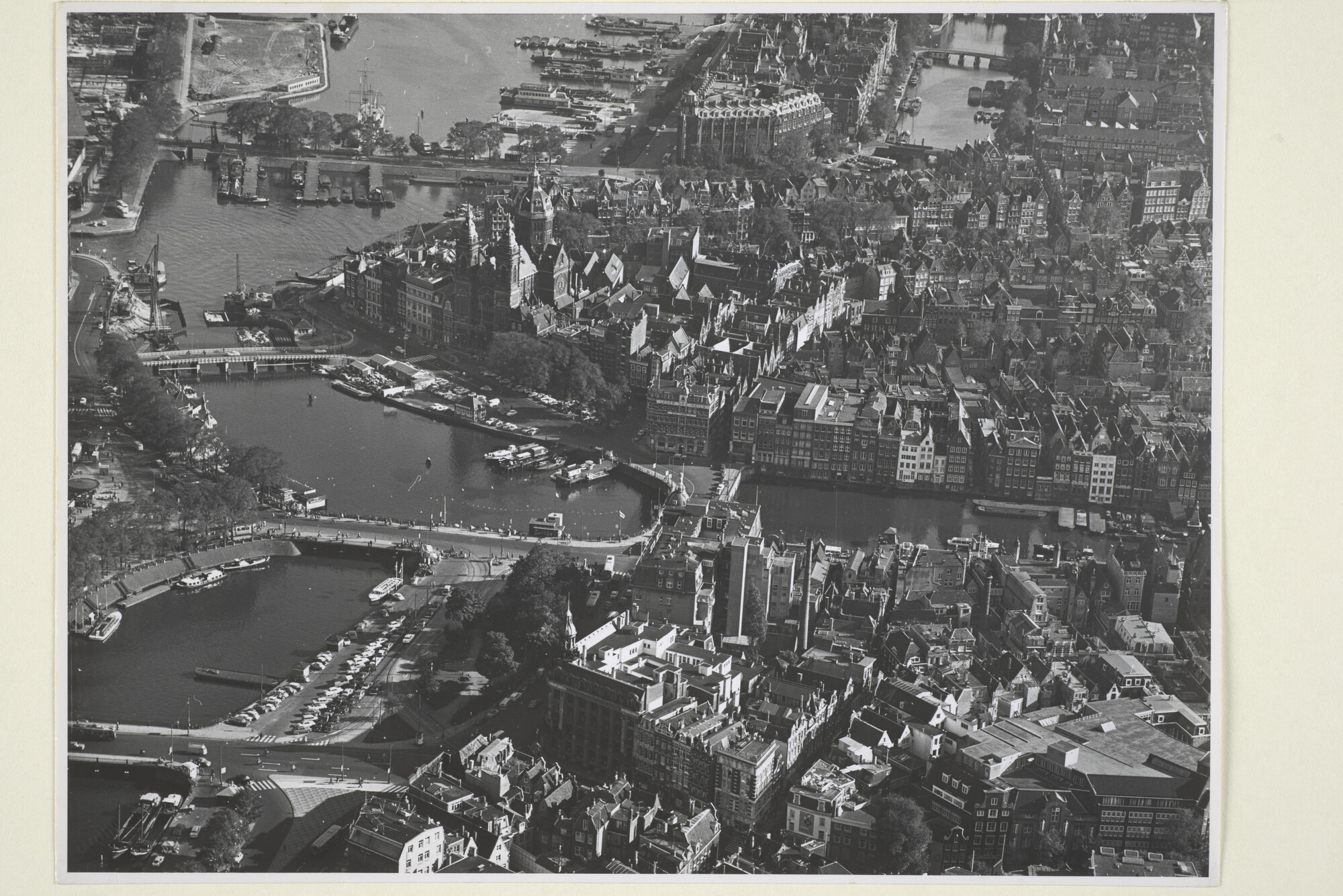 1998.0398; Luchtfoto met stadsgezicht in Amsterdam: het Open Havenfront achter het Centraal Station, met het Victoria Hotel, Damrak en het Scheepvaarthuis; foto