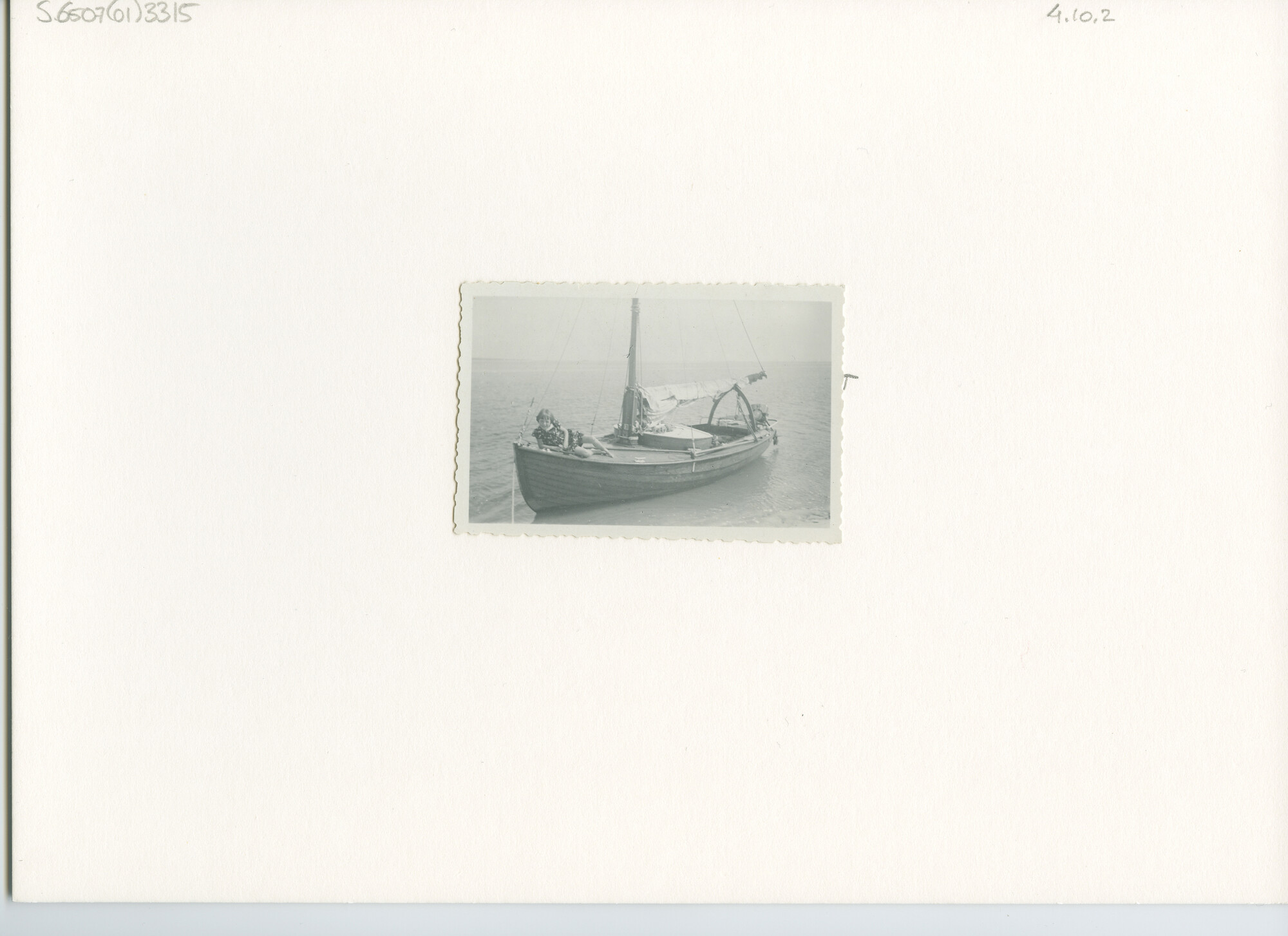 S.6507(01)3315; Foto van het blank houten overnaads gebouwde zeiljacht Sterntje met vaste buiskap en buitenboord motor; foto