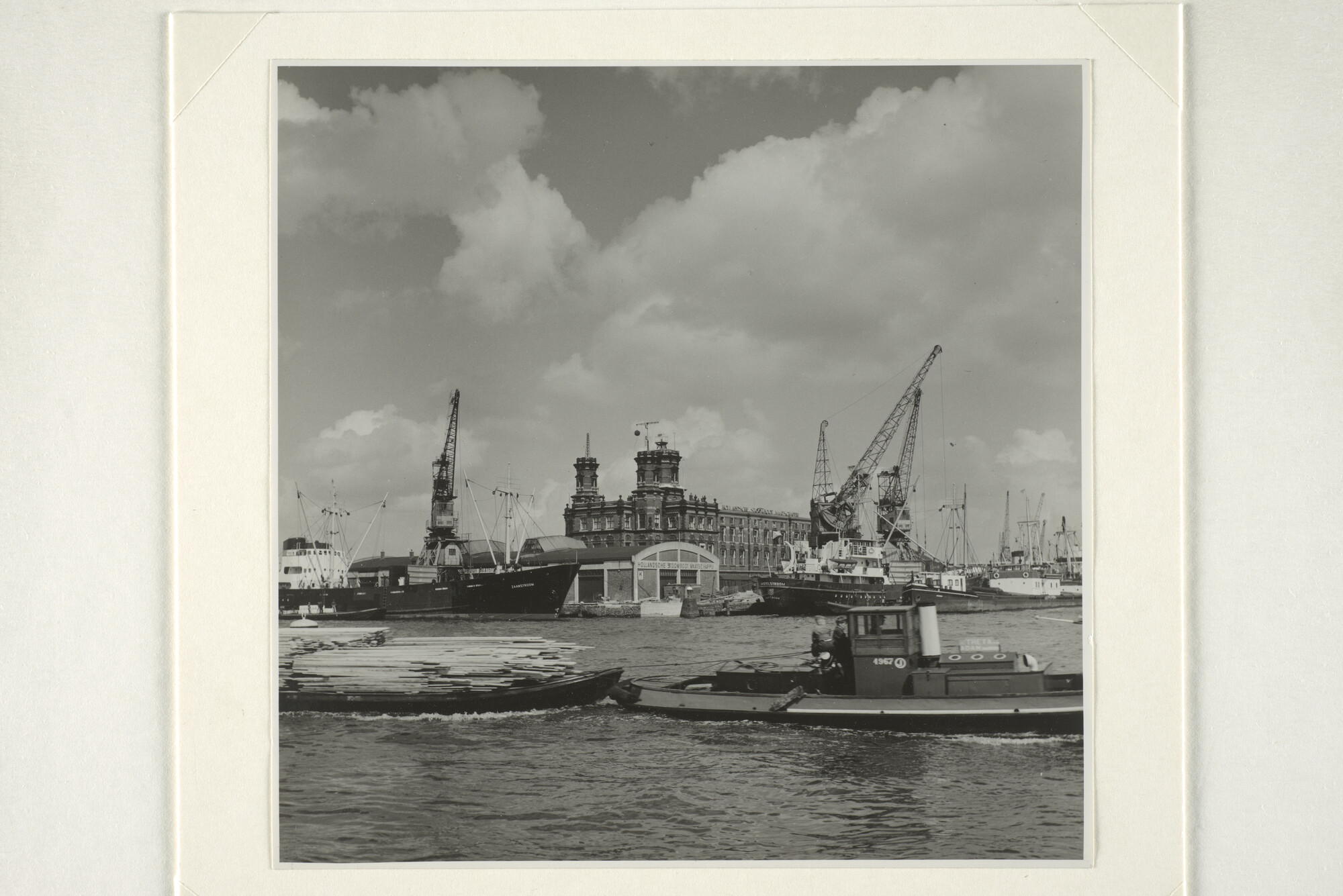 1998.0103; Gezicht op de kop van de Handelskade bij het KNMI-gebouw en de loodsen van de Hollandsche Stoomboot Maatschappij, 1955; foto
