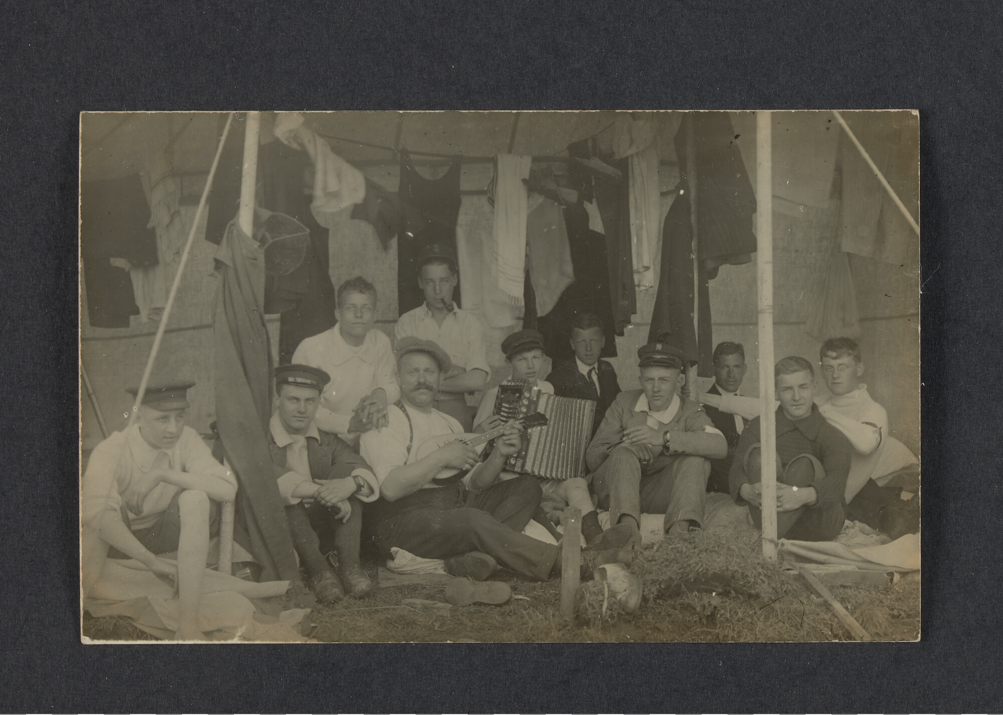 2022.0006; Zwart-wit foto van een groep jongens en een kampleider tijdens het eerste waterkamp voor jongens in Langweer (De Friese Meren) in 1915; foto