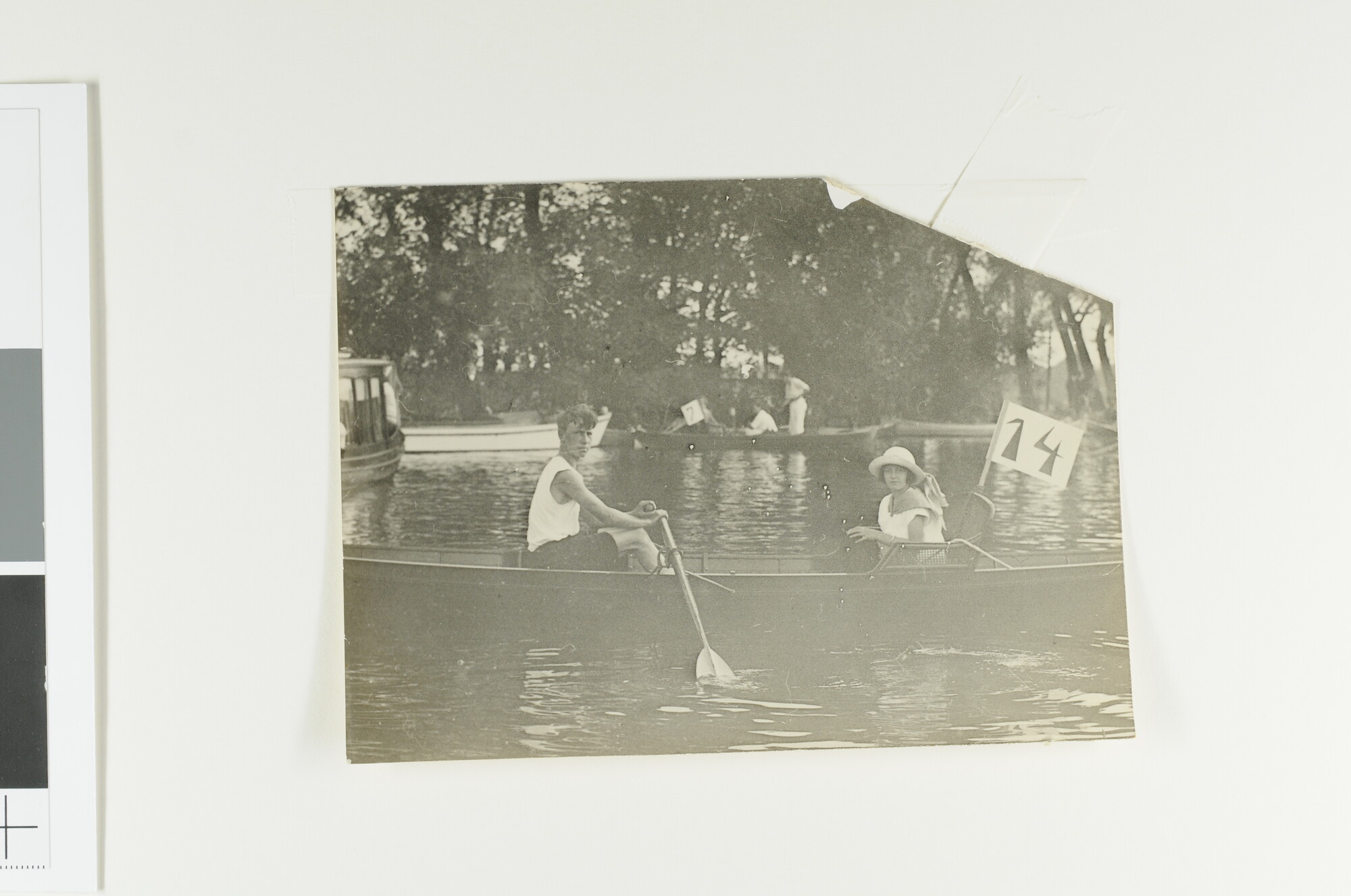 A.5675(65); Roeier met stuurvrouw in een overnaads gebouwde roeiboot (met nummer 14); foto