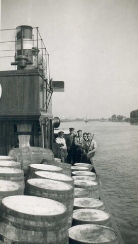 2002.0629; Het stoomschip 'Harlingen I' varend op de Hollandse IJssel, met vaten als deklast; daarachter de bemanning, poserend; foto