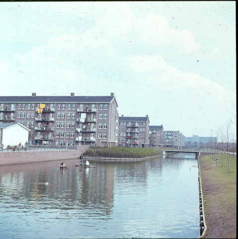 S.9100(0684); Drie jongens op vlotje in de Van Tienhovengracht te Amsterdam-Slotermeer; diapositief