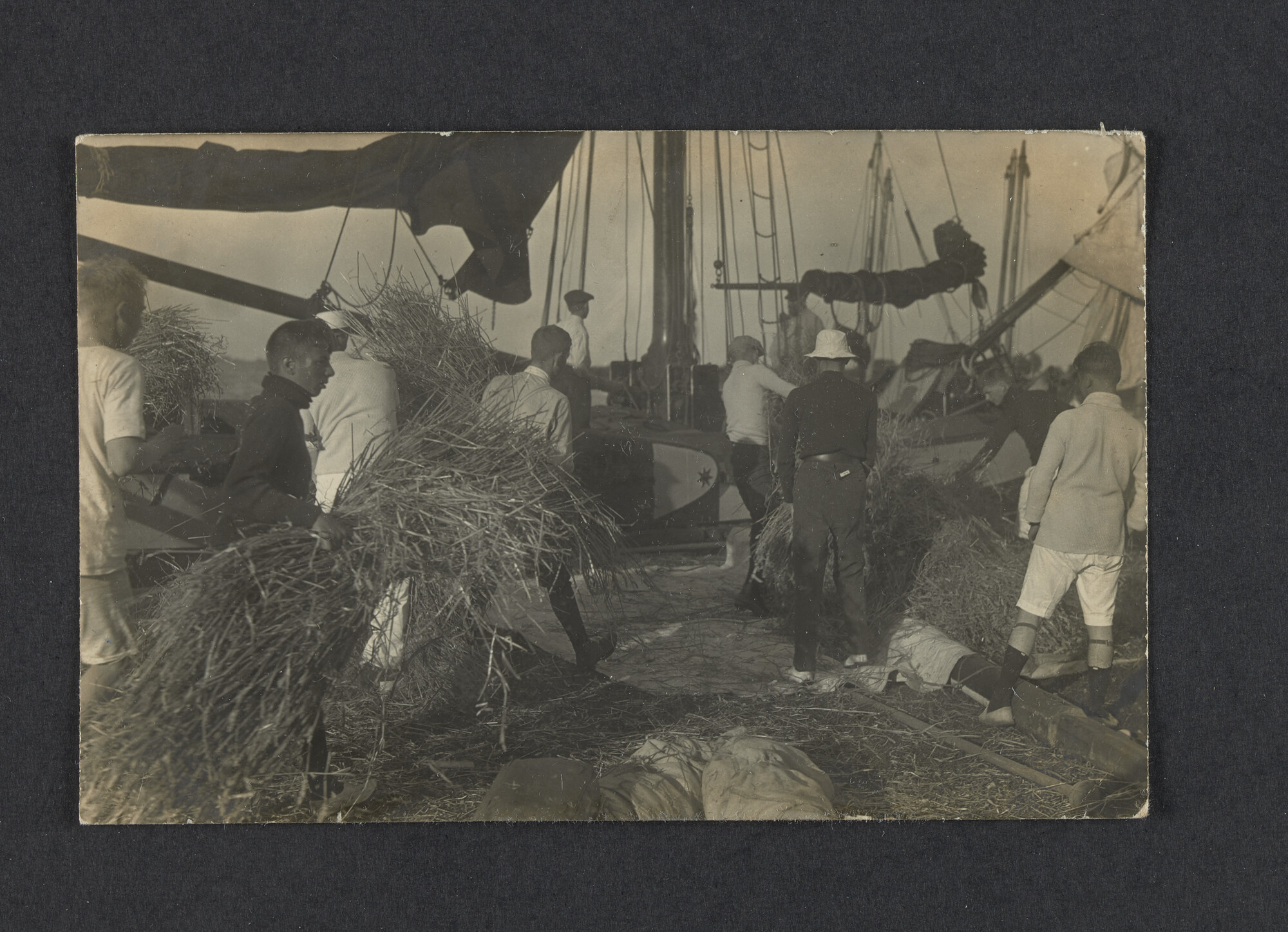 2022.0016; Zwart-wit foto van het laden van een schip (met stro) tijdens het eerste waterkamp voor jongens in Langweer (De Friese Meren) in 1915; foto