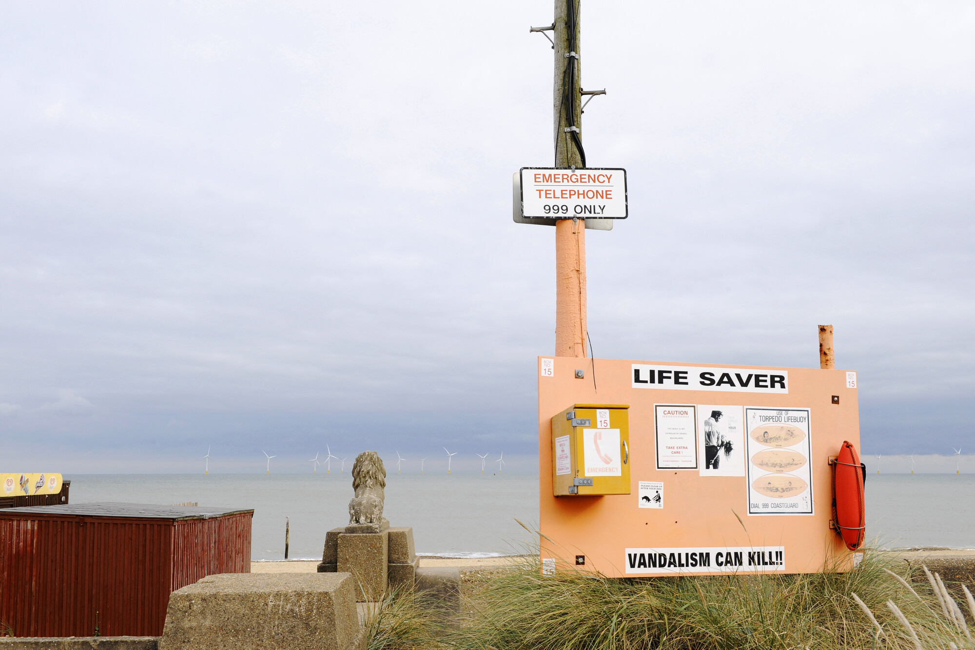 2019.0252; Kleurenfoto van een bord met een noodtelefoon, een reddingsboei en informatie, aan het strand van Great Yarmouth, Engeland, 2008; foto