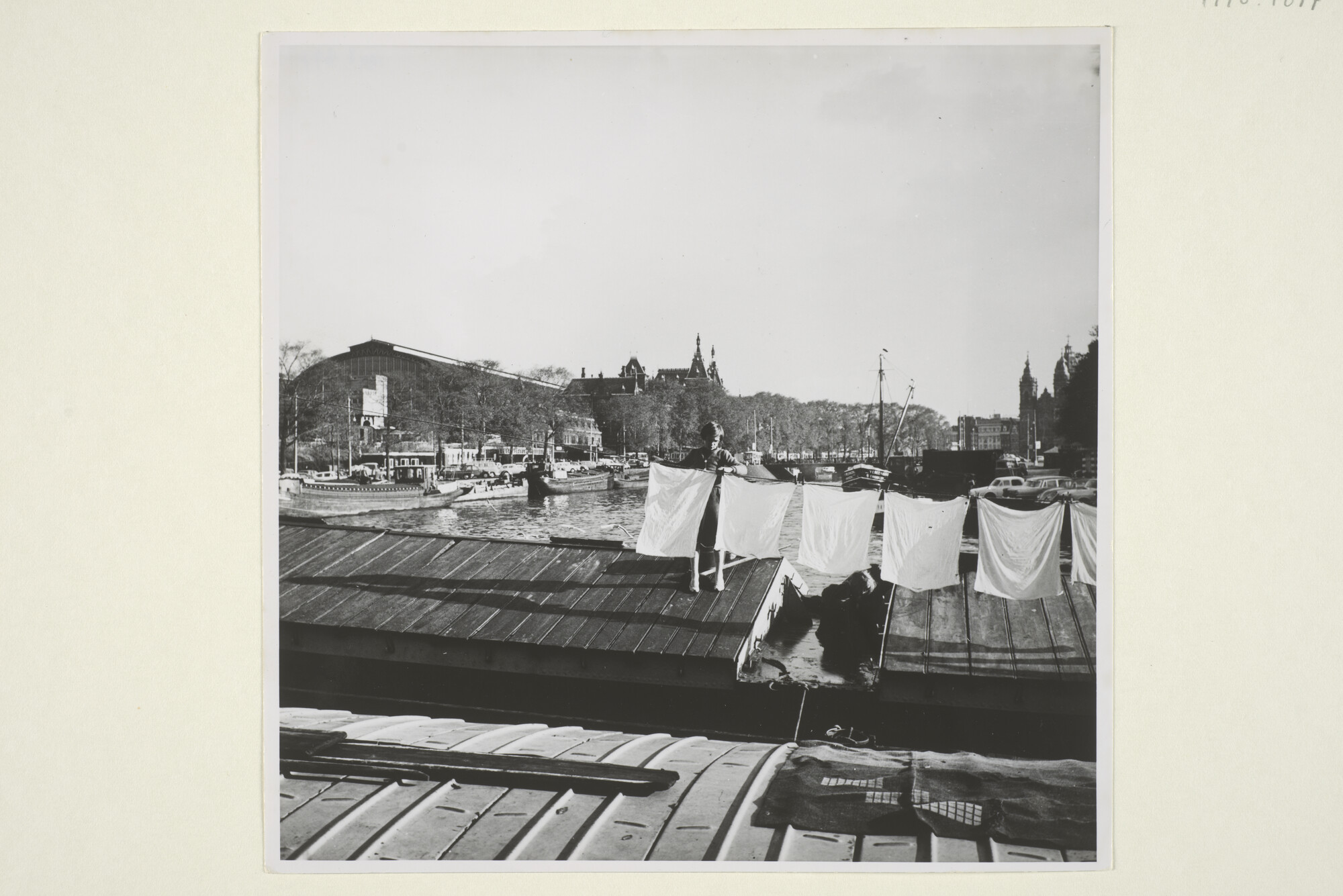 1998.1677; Stadsgezicht te Amsterdam: het Open Havenfront, gezien vanaf de Droogbak bij het Centraal Station, richting Oosterdok, omstreeks 1965; foto