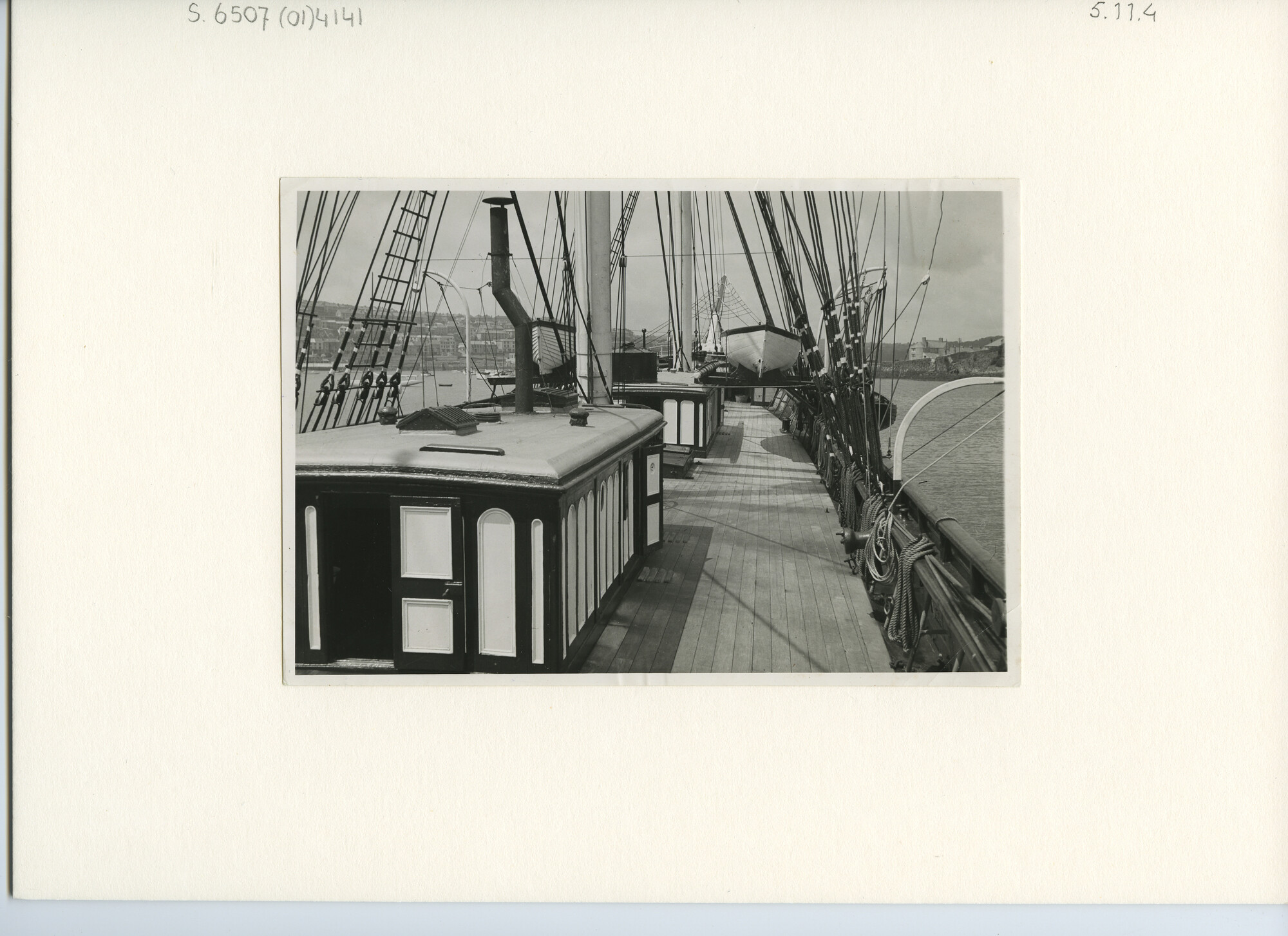 S.6507(01)4141; Dekaanzicht op een driemast houten zeilschip voor anker liggend in een baai; foto
