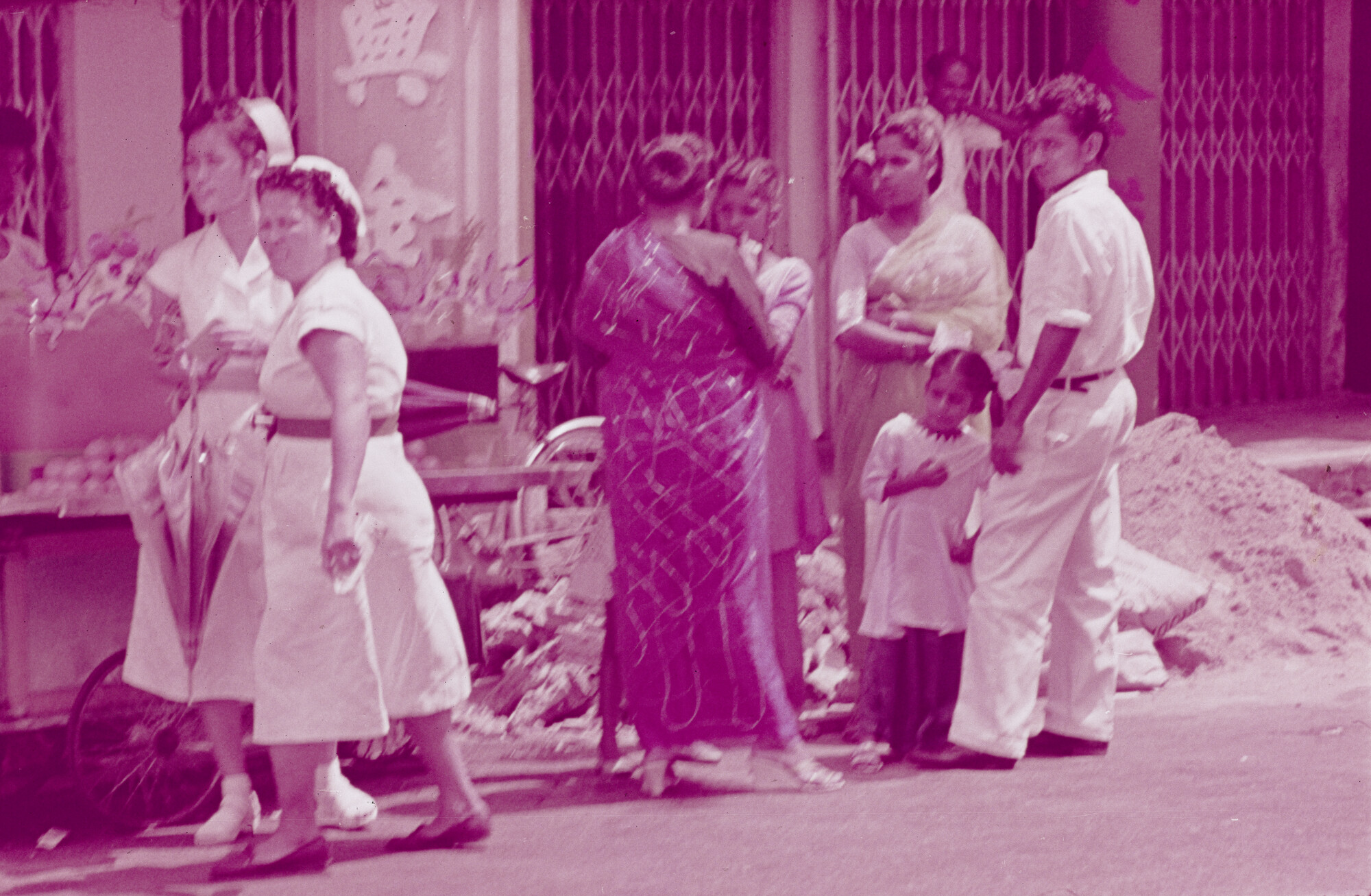 2015.0457; Dia van twee zusters en inheemse bevolking in een straat in Singapore; diapositief