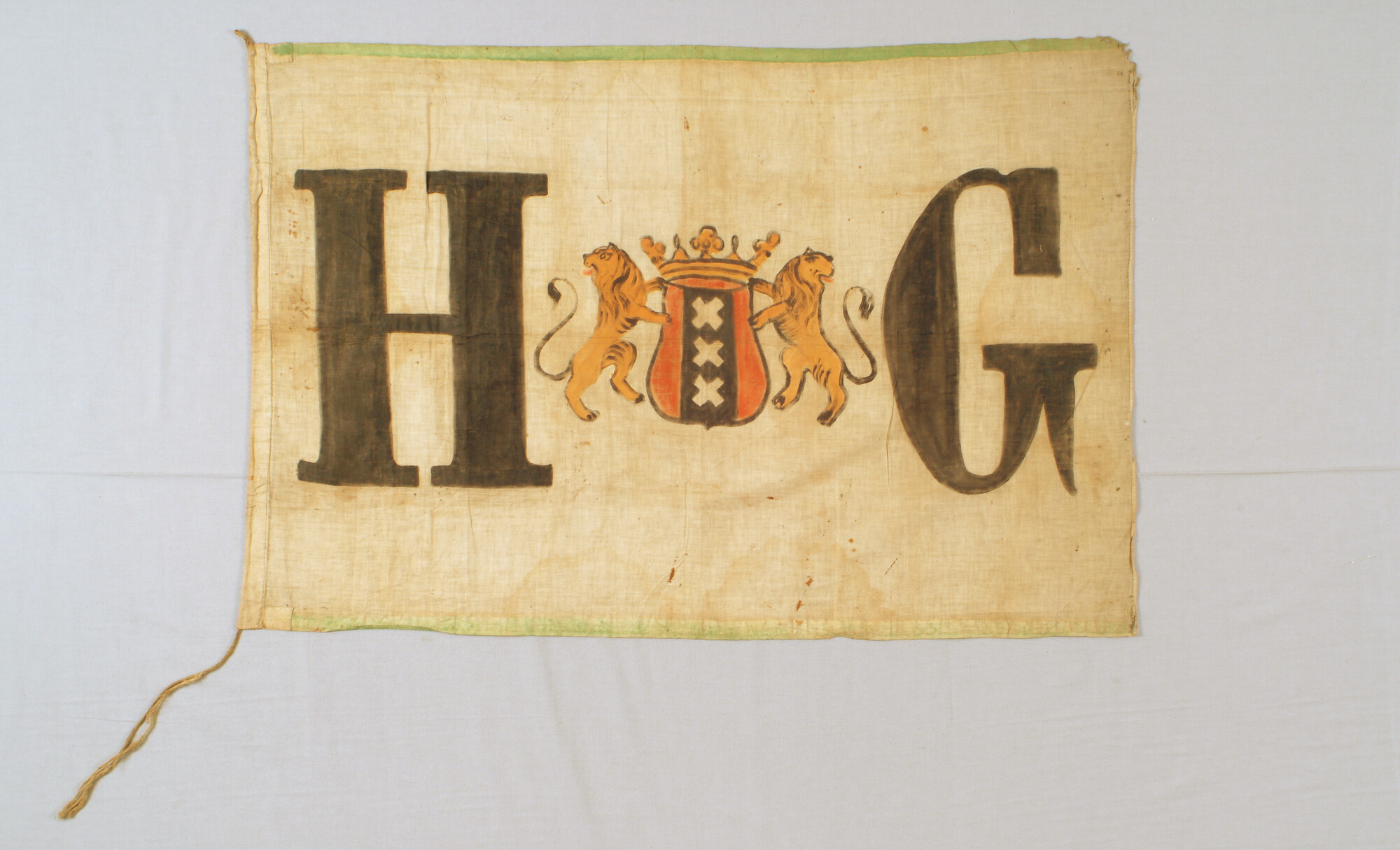S.3977; Vlag met het Amsterdamse wapen, geflankeerd door de letters H en G; vlag