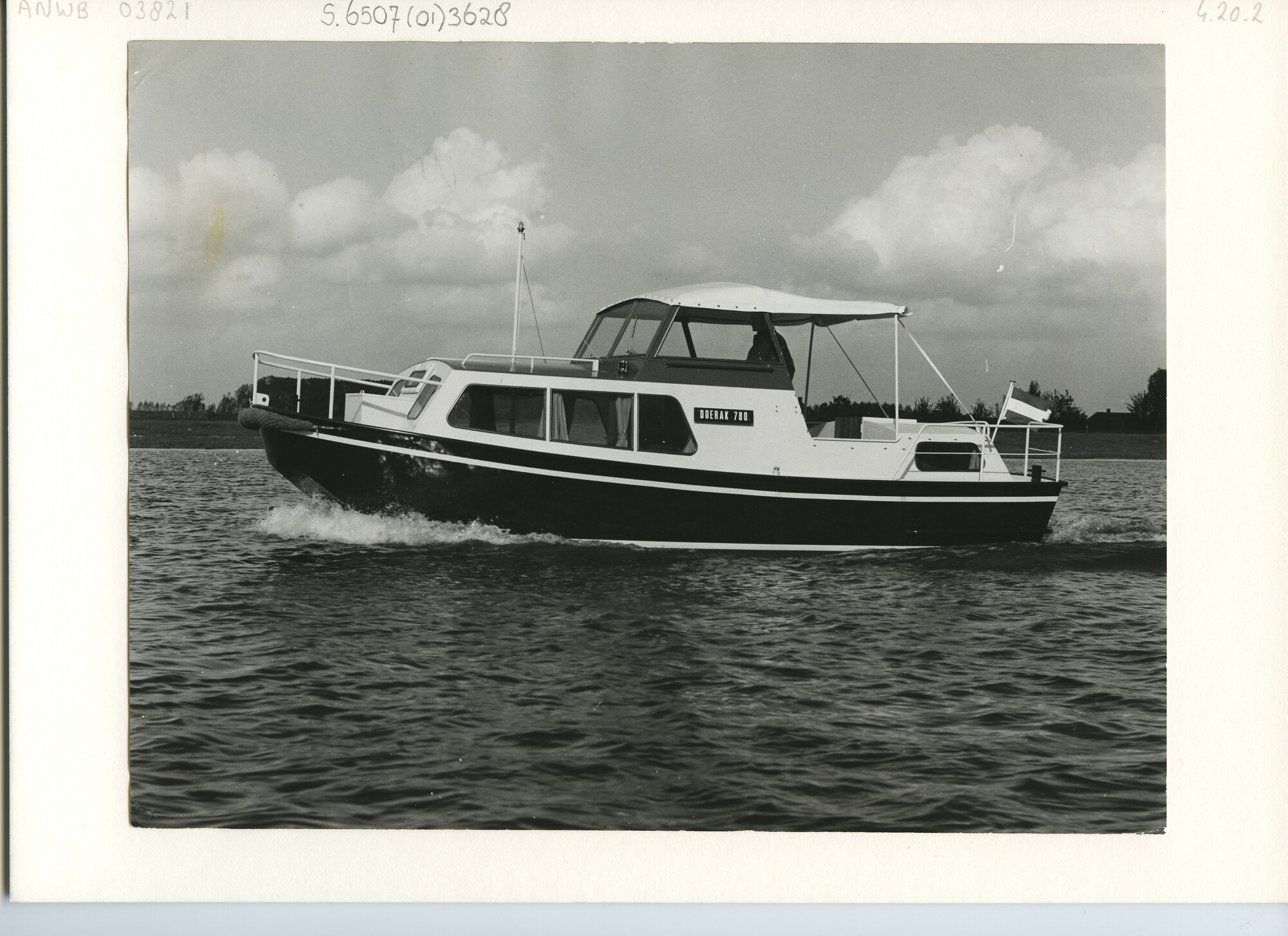 S.6507(01)3628; Foto van het donkere kajuitmotorjacht met witte opbouw type Doerak 780 varend op ruim water; foto