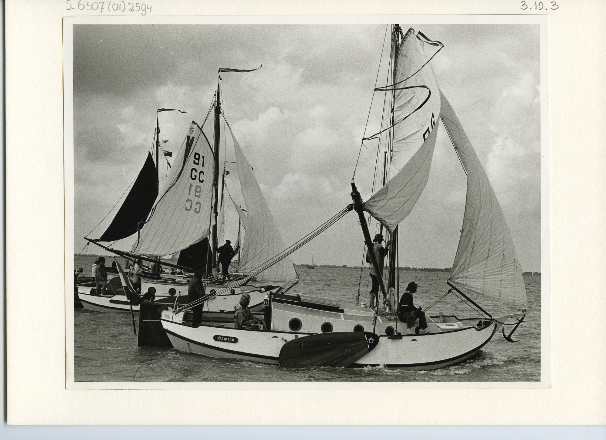 S.6507(01)2594; Zijaanzicht van drie wit geschilderde grundels met gekat grootzeil nabij Grouw. Zichtbaar: Sapitau, GC 86 en 91 GC.; foto