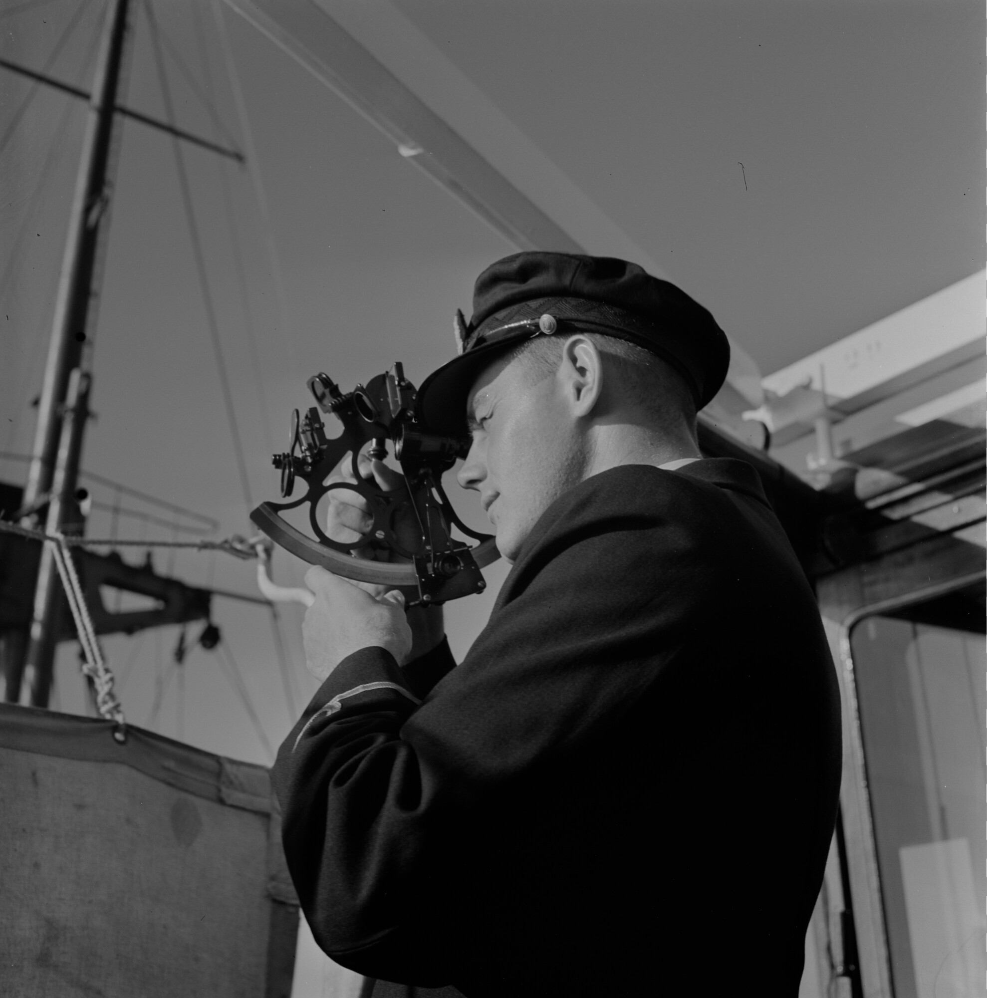 2015.1639; Negatief van stuurman die een sextant gebruikt op een schip; negatief