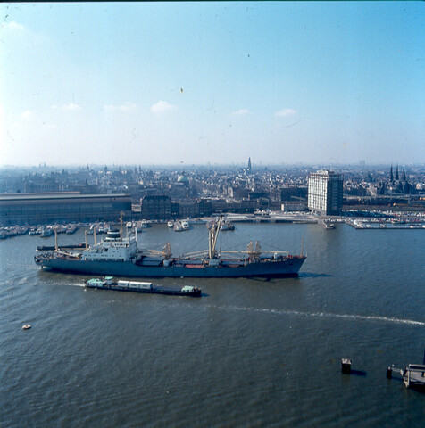 S.9100(7022); Dia van het binnenvaartschip 'Steenwijk' geladen met KNSM-containers het vrachtschip 'Trident Amsterdam' passerende op het IJ; diapositief