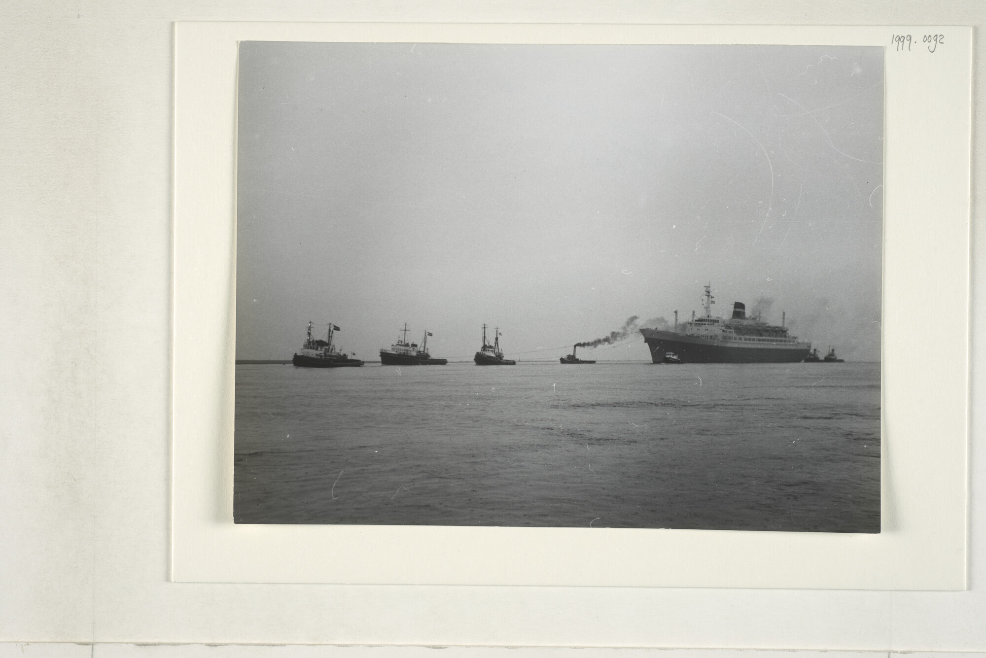 1999.0092; Het passagiersschip ss. 'Statendam' van de HAL wordt na de eerste proefvaart teruggesleept; foto