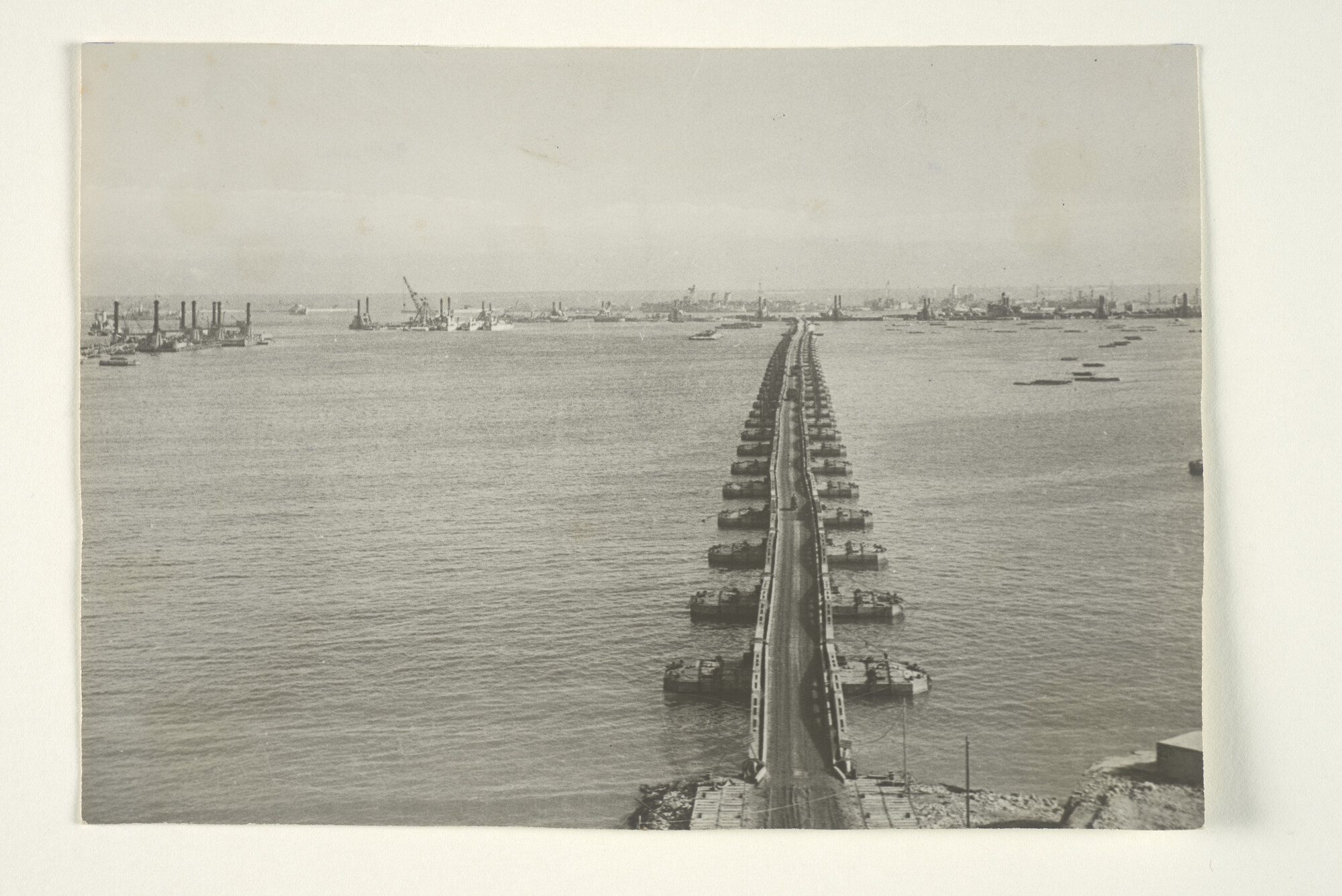2000.3491; 'General view of prefabricated port in position at Arromanches.' De Mulberry-haven te Arromanches vanaf de kustplaats gezien met Gooseberry-pier [...]; foto
