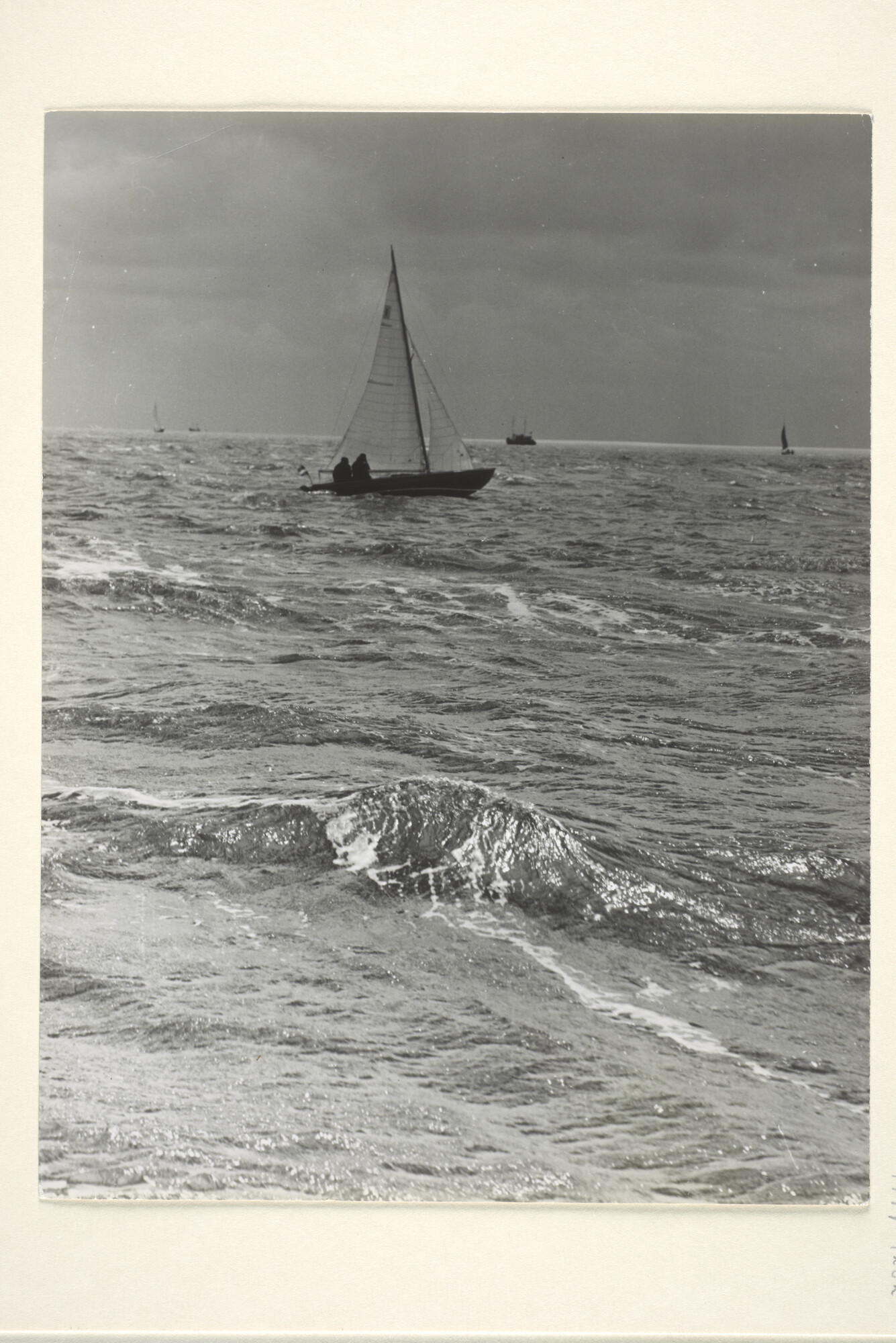 1997.1232; Gezicht vanaf het strand met een uit de branding varende zeilboot; foto