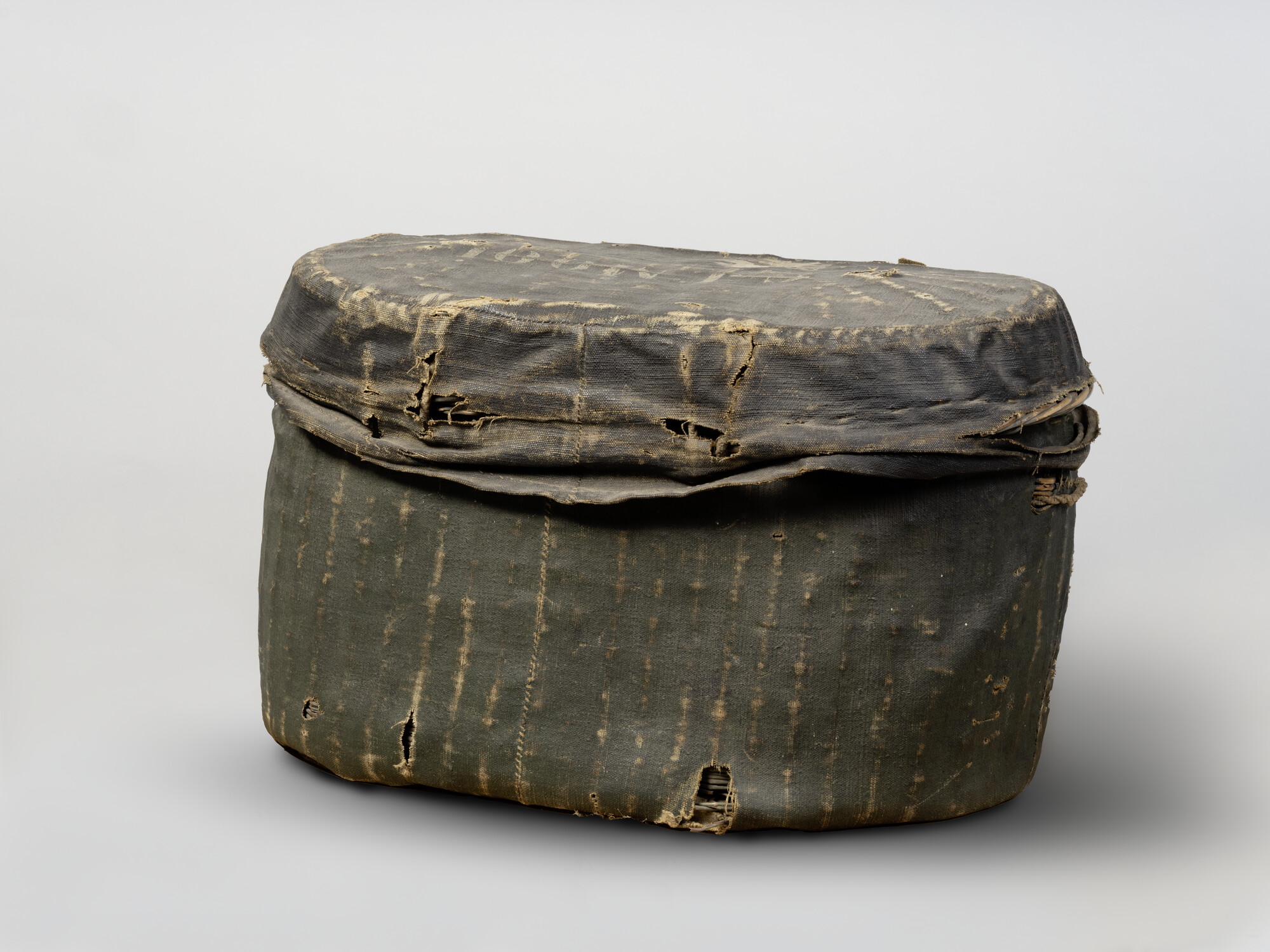 S.6442; Mand van gevlochten teen, geheel bekleed met zwart geschilderd persenning; reismand