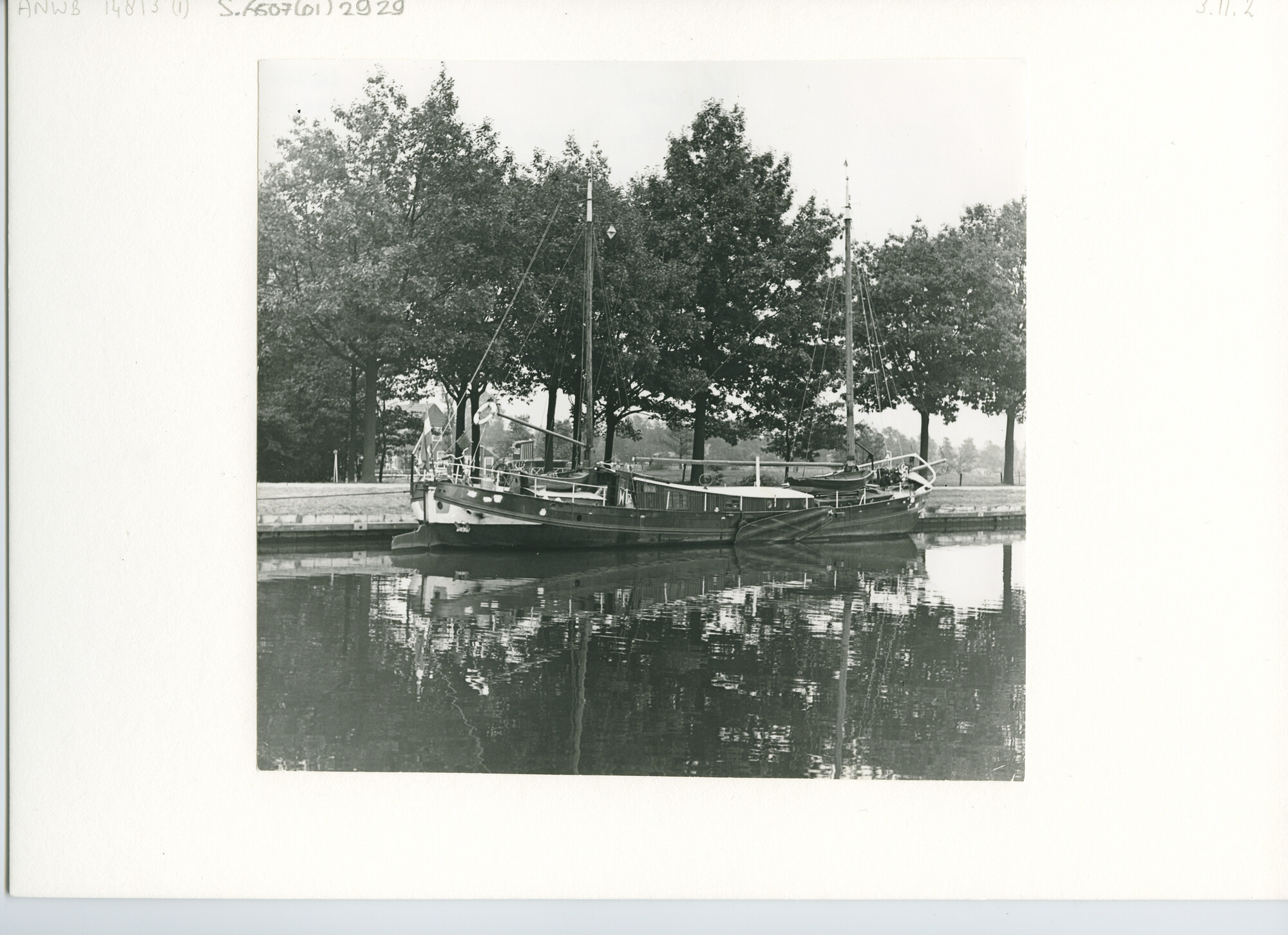 S.6507(01)2929; De tweemast klipperaak Odin afgemeerd in een kanaal met bomen en een boerderij op de achtergrond; foto