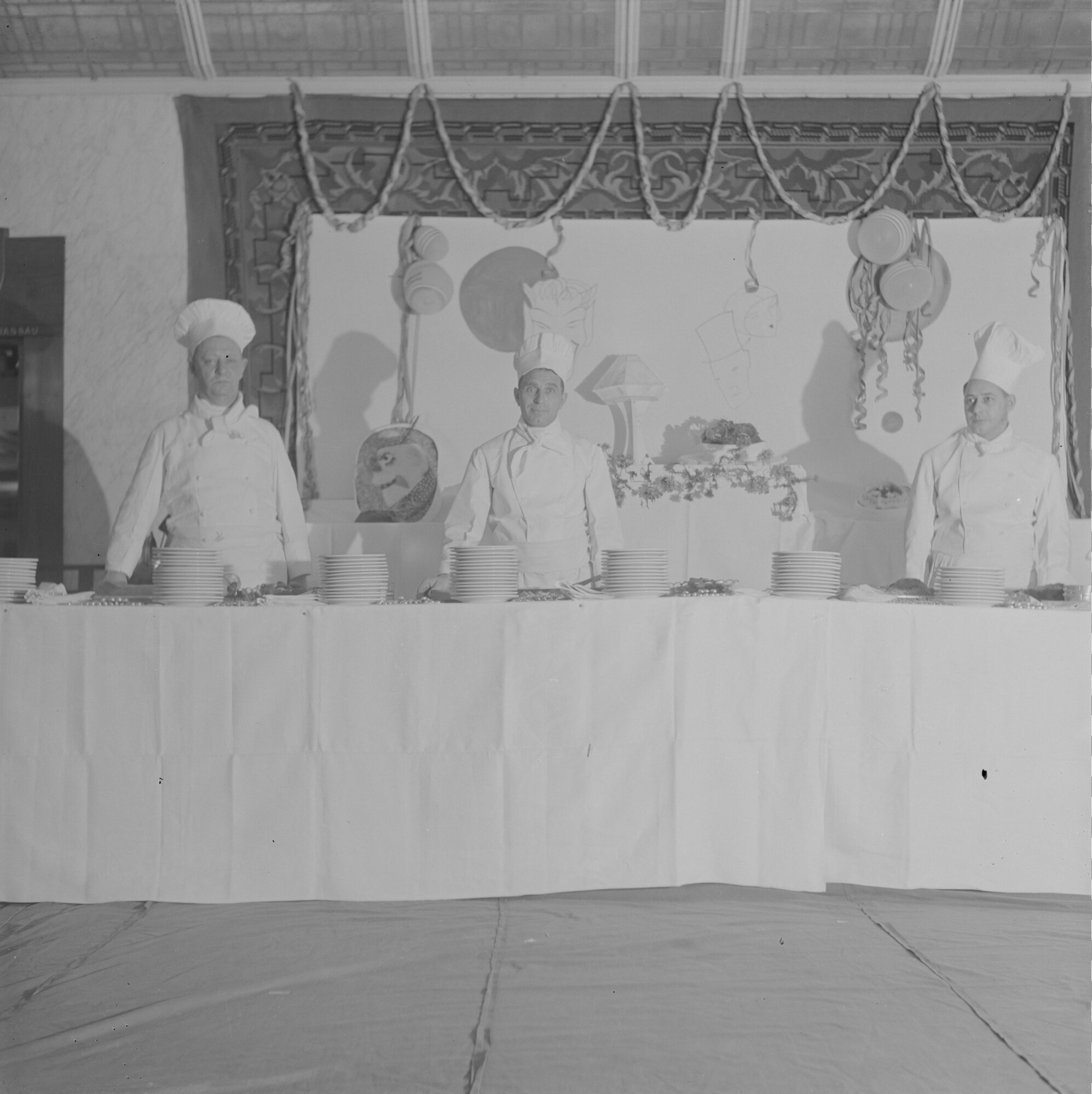 2015.1689; Negatief van keukenpersoneel achter een feestelijk buffet op een schip; negatief