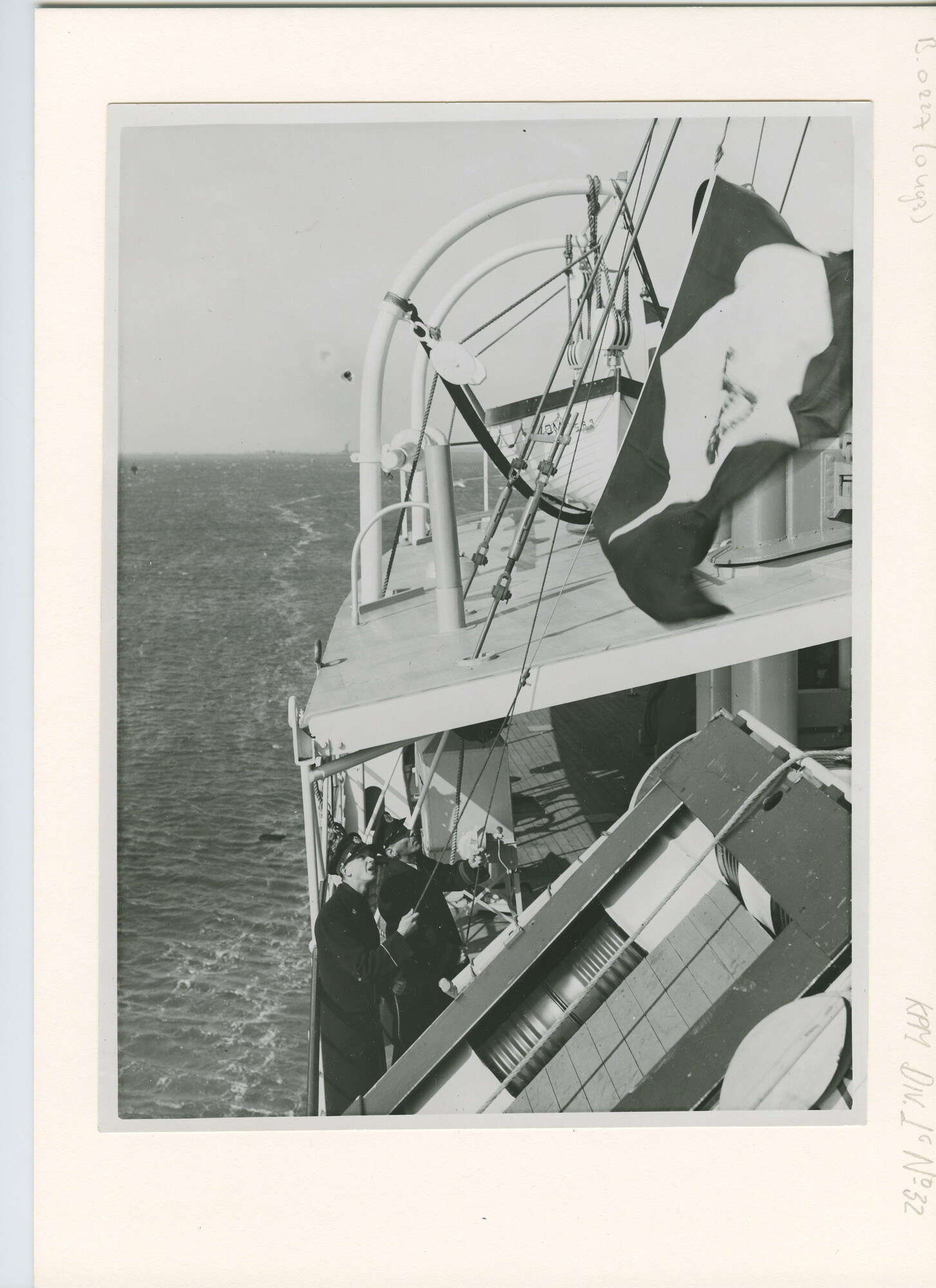 B.0227(0493); Foto van het hijsen van de KPM-vlag tijdens de proefvaart van ms. Van der Capellen; foto