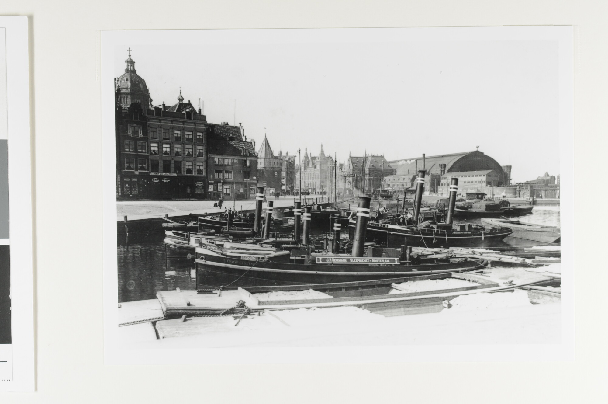 1992.1428; Sleepboten van de reederij J.H. Bergmann afgemeerd aan de Prins-Hendrikkade te Amsterdam, met de achtergrond de St. Nicolaaskerk [...]; foto