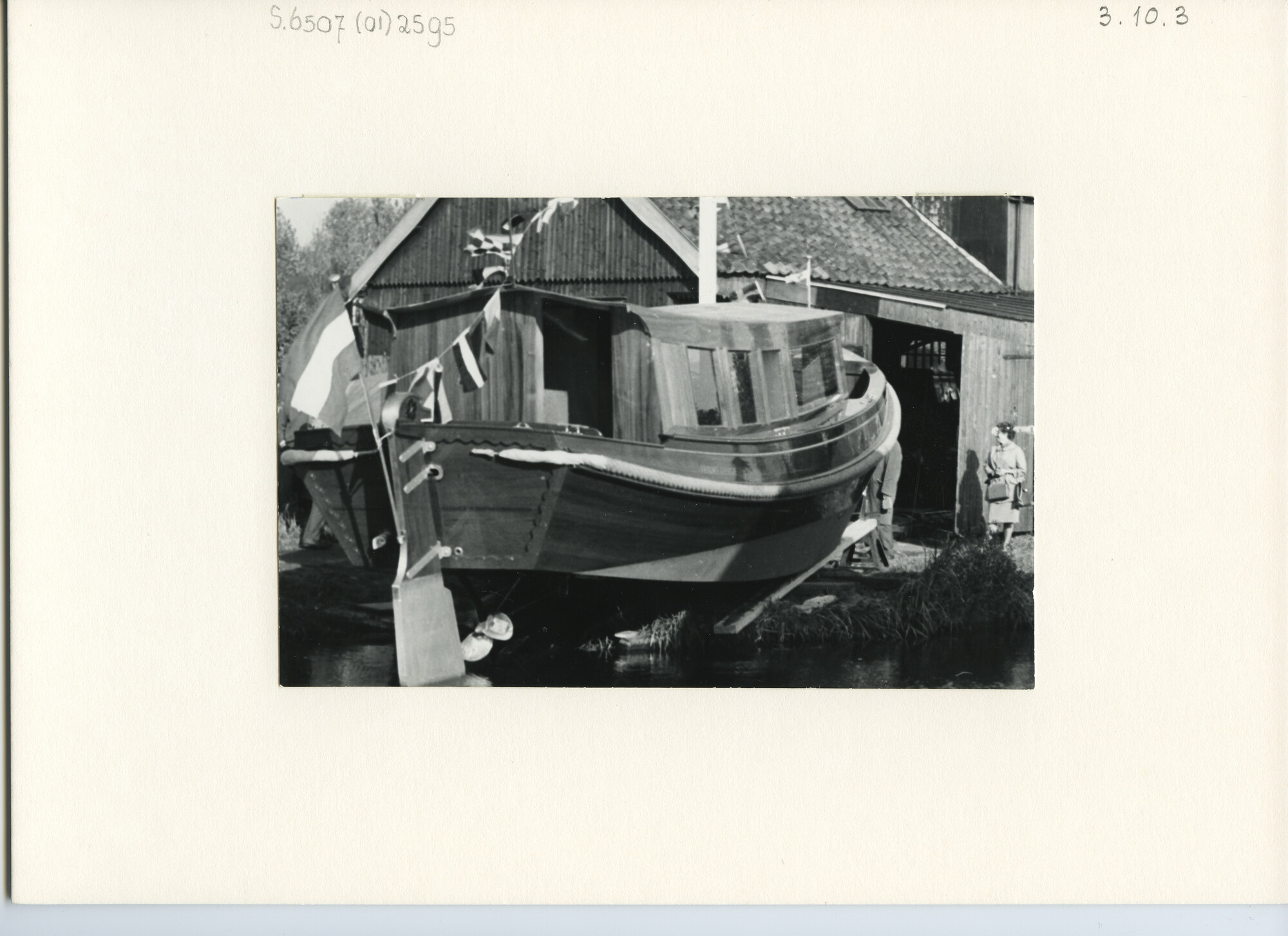 S.6507(01)2595; Een houten grundel motorjacht gepavoiseerd op de helling; foto