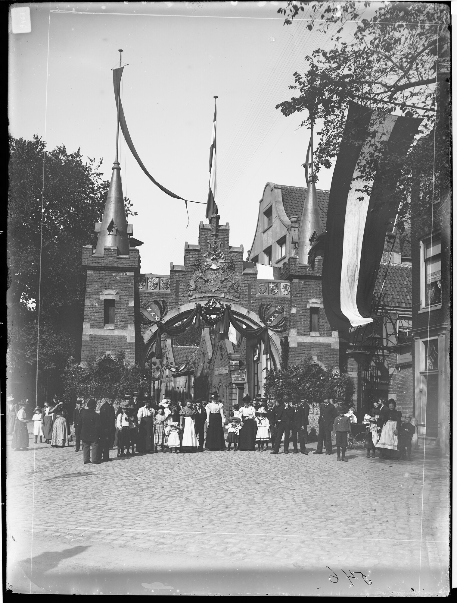 S.1156(06)128-06; Glasnegatief van de inhuldigingsfeesten van koningin Wilhelmina te Amsterdam. Groepsportret voor een versierde toegangspoort.; negatief