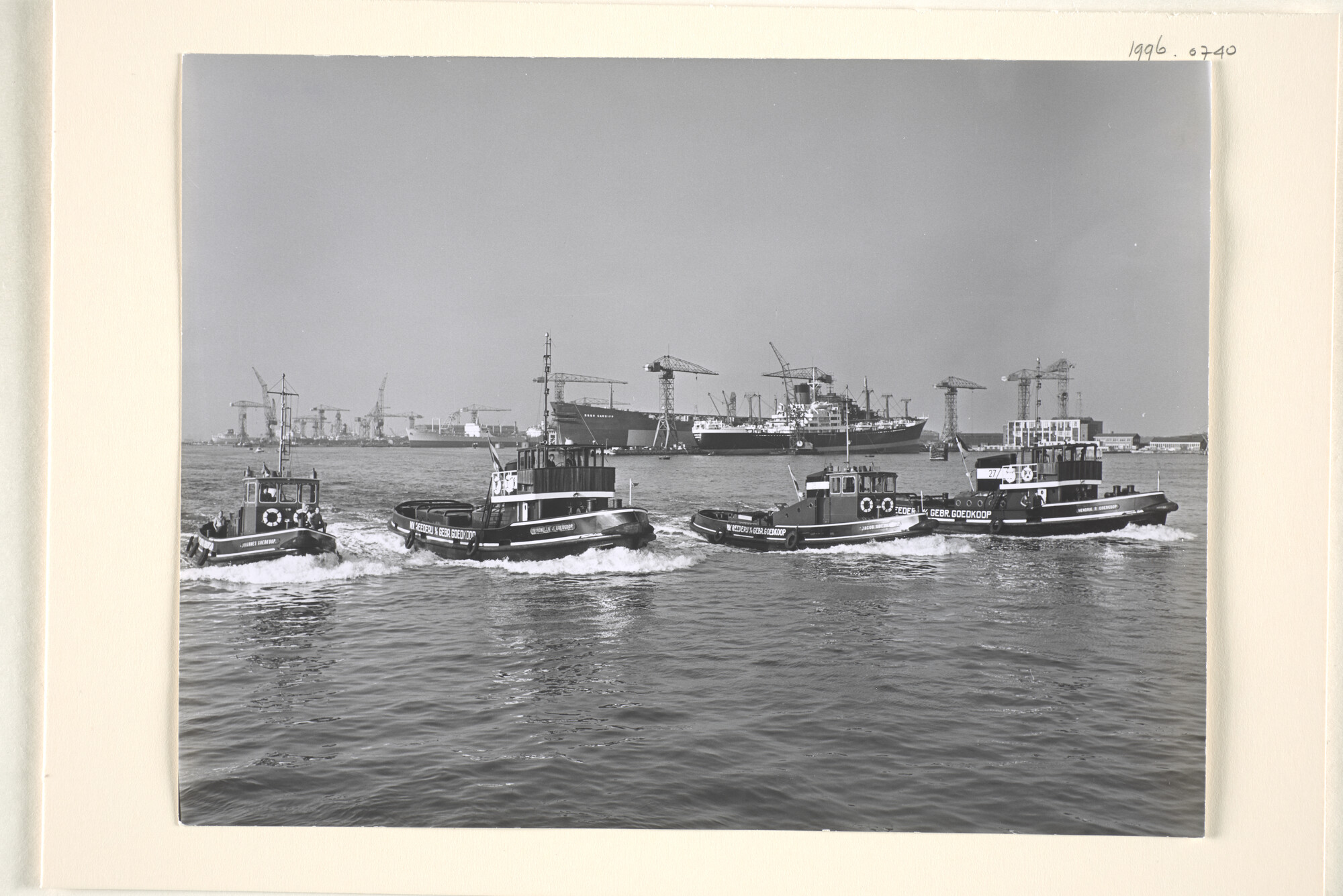 1996.0740; De haven van Amsterdam: de werf van de NDSM in Amsterdam met op de voorgrond vier sleepboten van de Reederij v/h Gebr. Goedkoop: de 'Johannes Goedkoop' [...]; foto