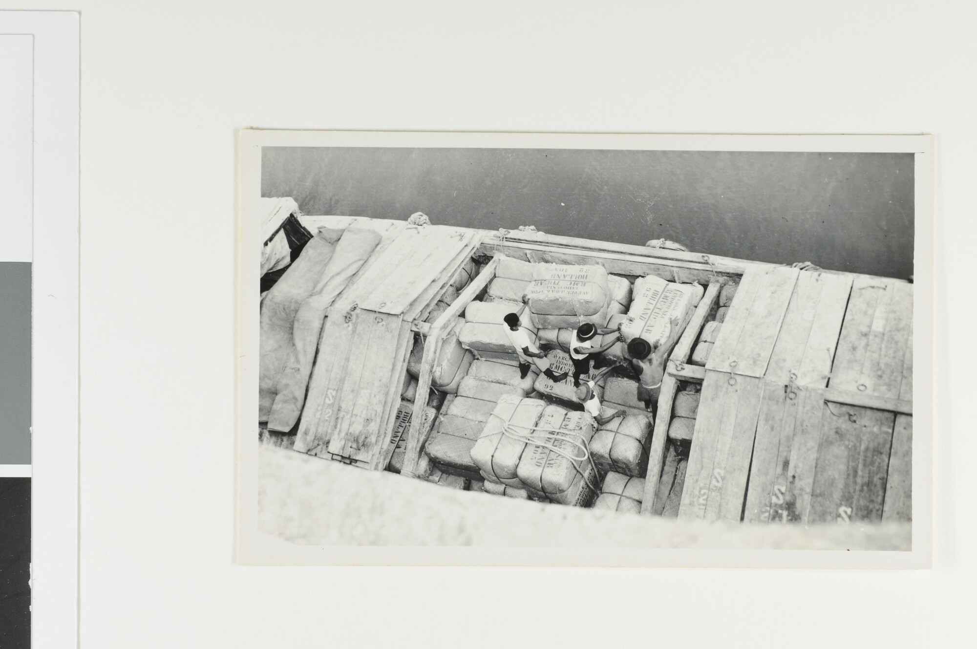 S.6577(03); Het stapelen van balen kapok in de prauw; fotoreportage