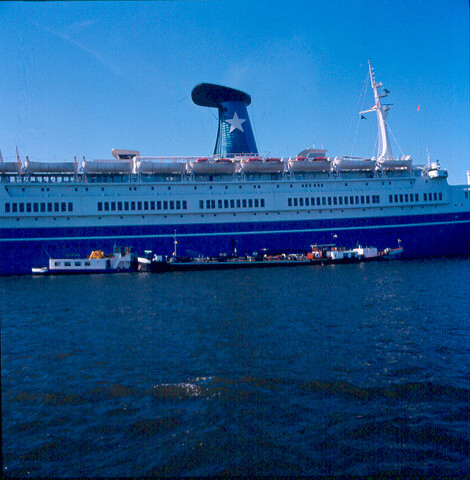 S.9100(7015); Dia van het Italiaanse cruiseschip Angelino Lauro (ex- Oranje van de SMN) afgemeerd bij de PTA in Amsterdame; diapositief