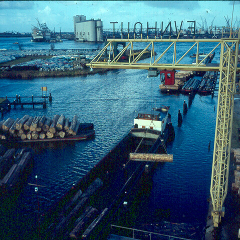 S.9100(1111); Dia van houtoverslag in haven Amsterdam: Fijnhouthandel [...]; diapositief