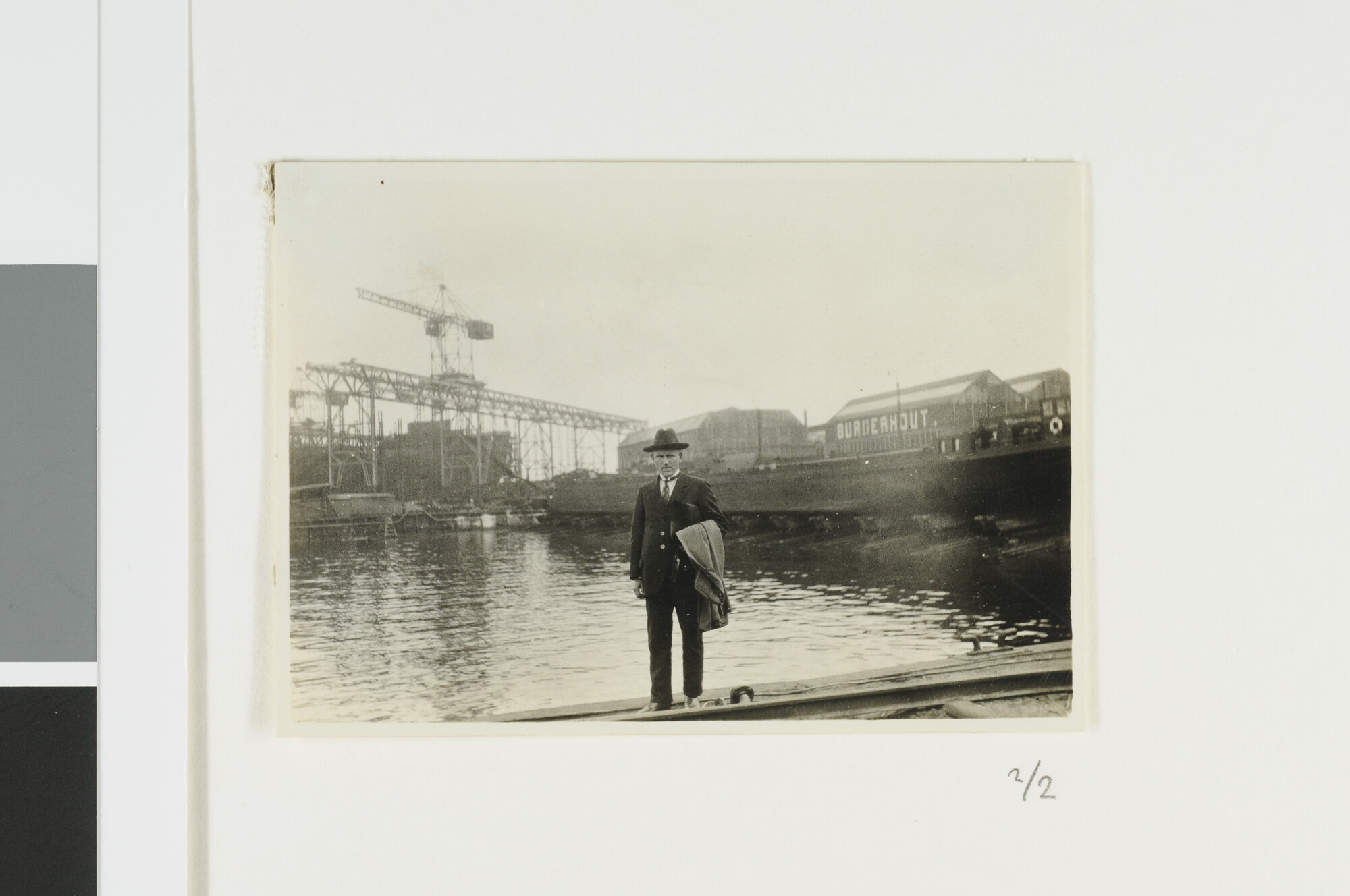 A.2867(03)001; J. Ouwens op de kade tegenover Burgerhout's Machinefabriek en Scheepswerf te Rotterdam (26 mei 1928). "Alexander André" in aanbouw op de helling en Hr.Ms. "Evertsen" en "Piet Hein" afgemeerd voor de werf; fotoreportage