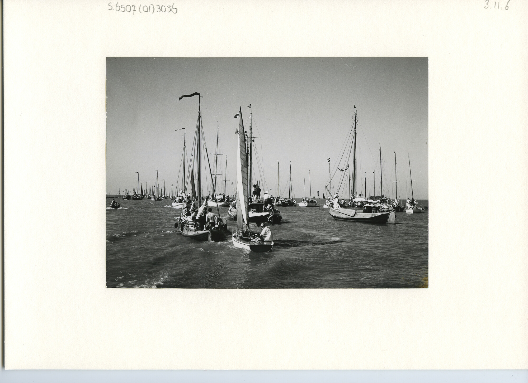S.6507(01)3036; Foto van een vloot van zeiljachten en ronde en platbodemjachten bijeen op open water; foto