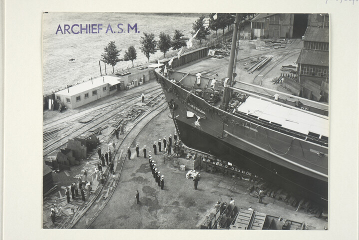 S.5219(12)0276; De doop van het vrachtschip ms. 'Vliestroom', gebouwd op de langshelling van de ASM: moment van stukslaan van de fles; foto