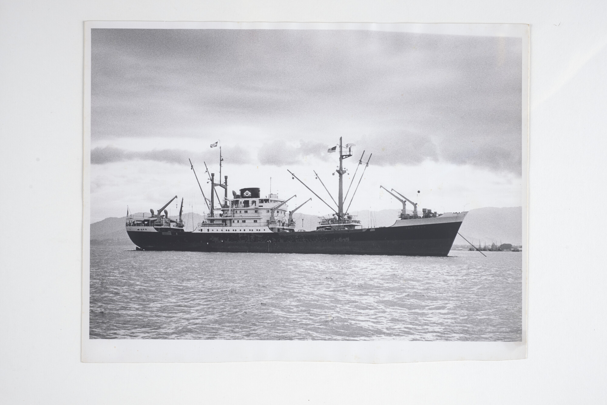 2014.0431; Zwart-wit foto van ms. Van Neck voor anker voor een kust; foto