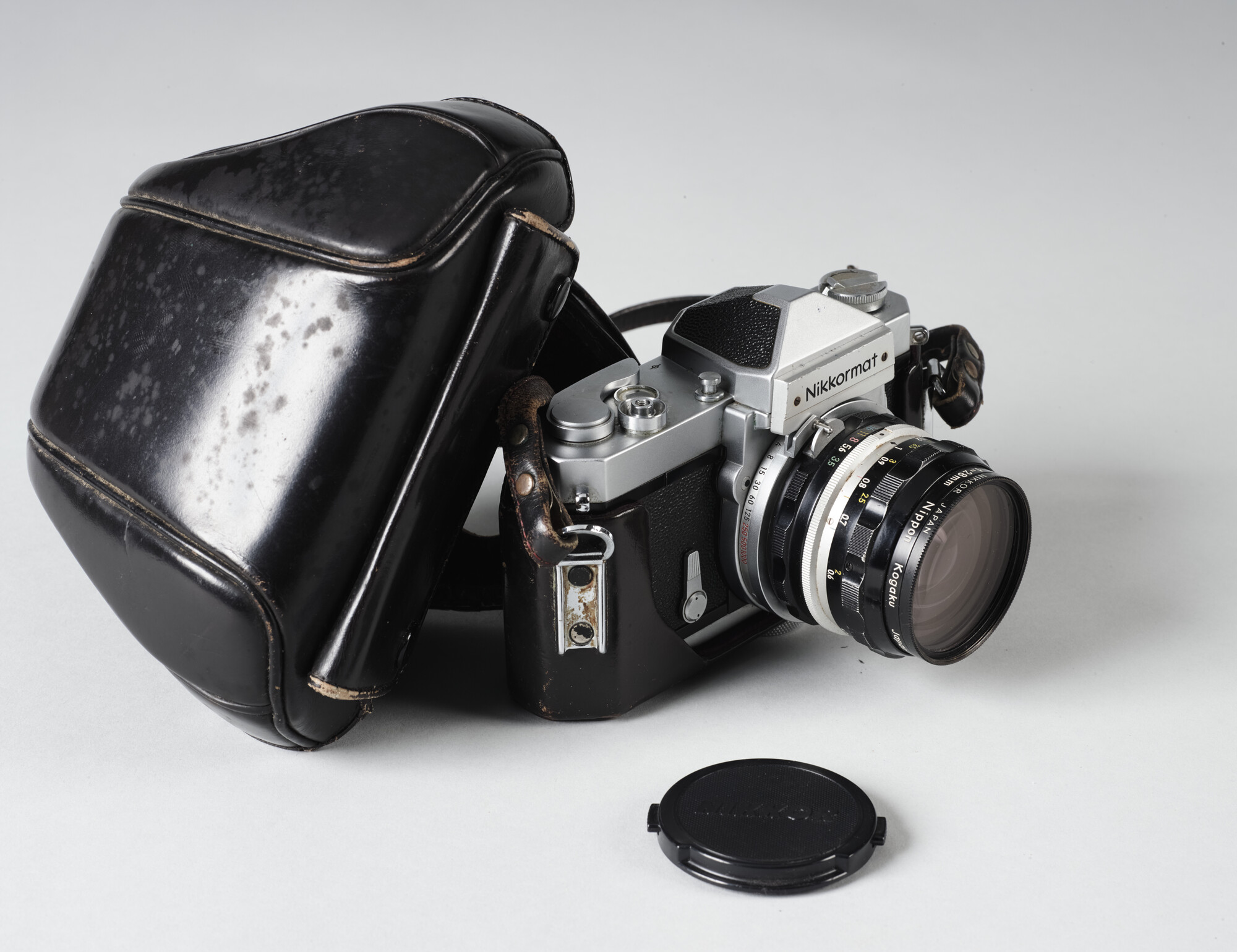 2019.1054-30; Fotocamera van het merk Nikkormat met lens en hoes; camera (fotografische uitrusting)