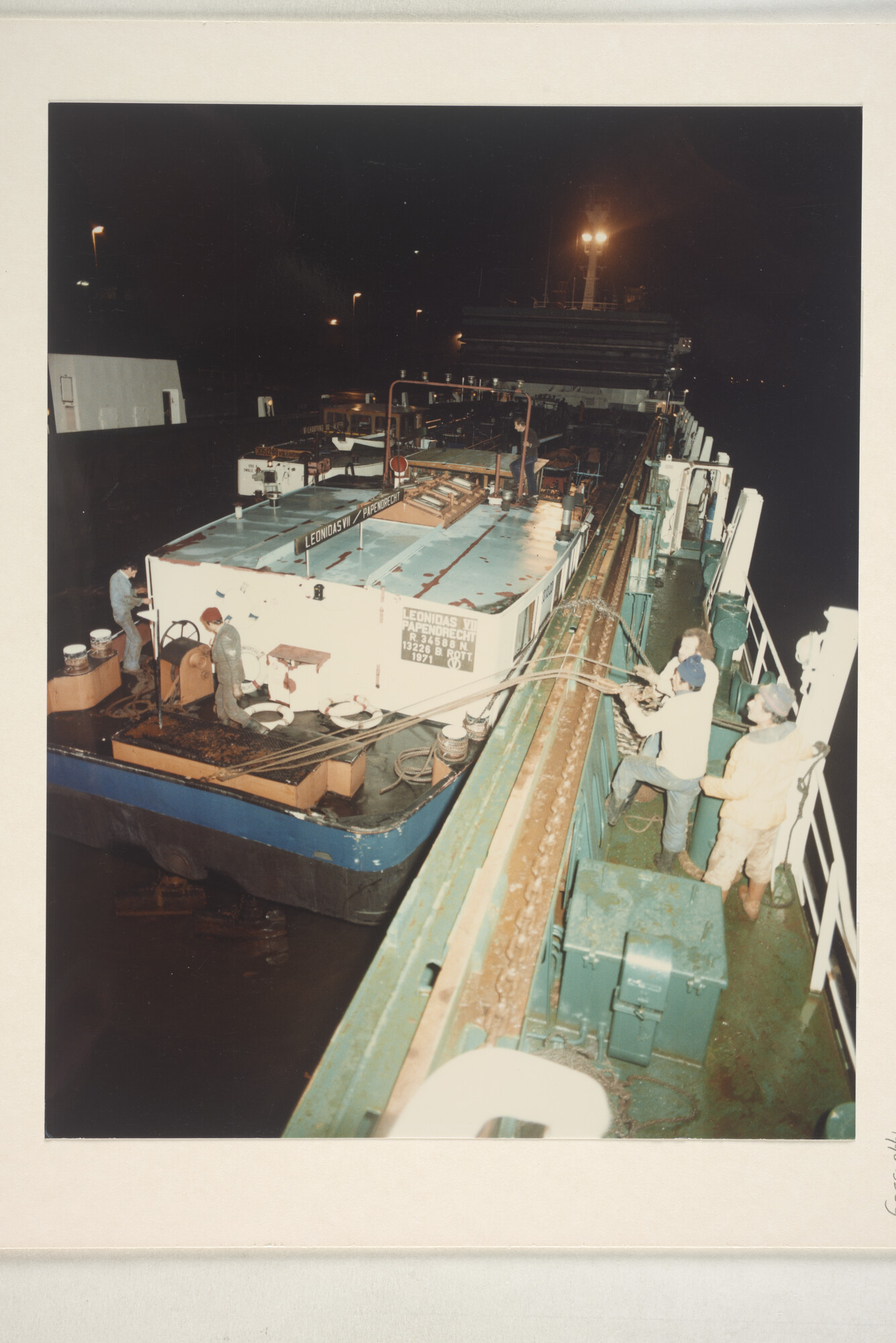 1996.3389; Avondopnames van het klaarmaken voor transport met een dokschip van de binnenvaarttankers ms. 'Leonidas VII' van Leonidas Tankvaart BV; fotoreportage