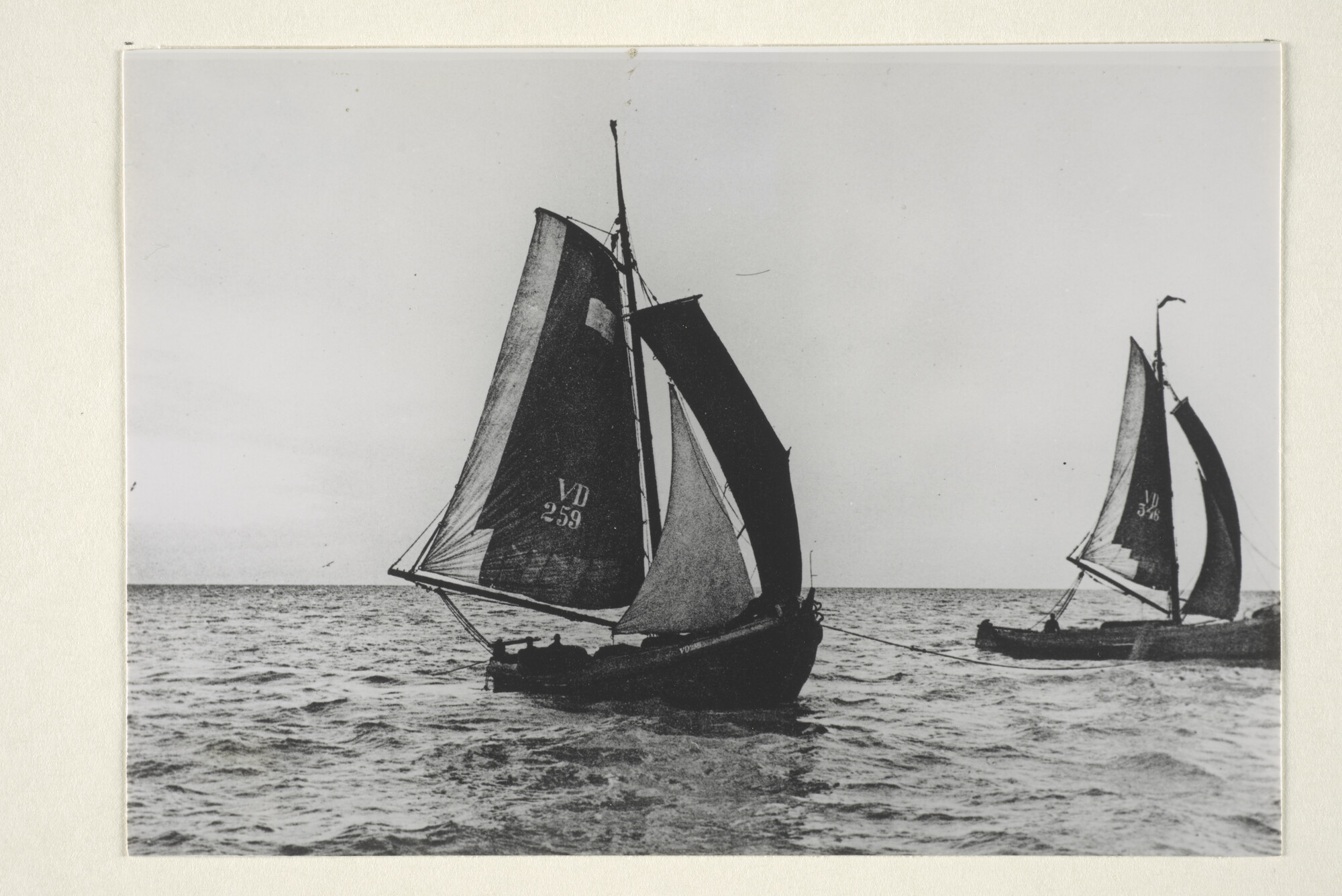 1997.1474; De Volendammer botters VD 259 en VD 346 aan de wonderkuil, de lijn tussen de schepen vanaf de boeg, omstreeks 1905; foto