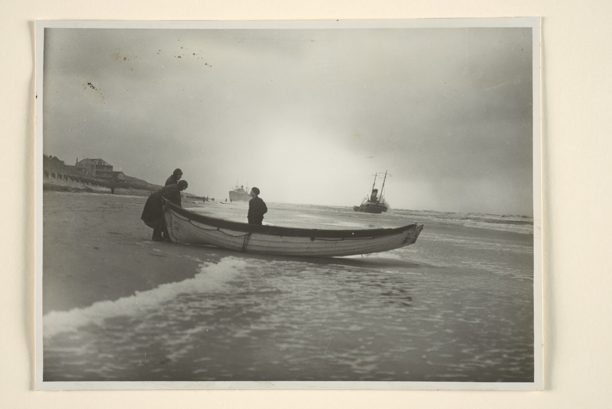 1996.1021; Twee mannen en een kind staan bij een kapot sloepje op het strand van Egmond aan Zee; foto