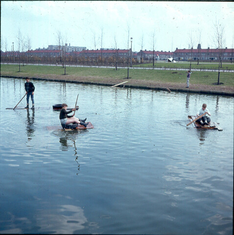 S.9100(0682); Drie jongens op vlotje in de Van Tienhovengracht te Amsterdam-Slotermeer; diapositief