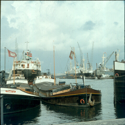 S.9100(0036); Buitenlandse zeeschepen en rijnaken in de Coenhaven te Amsterdam; diapositief